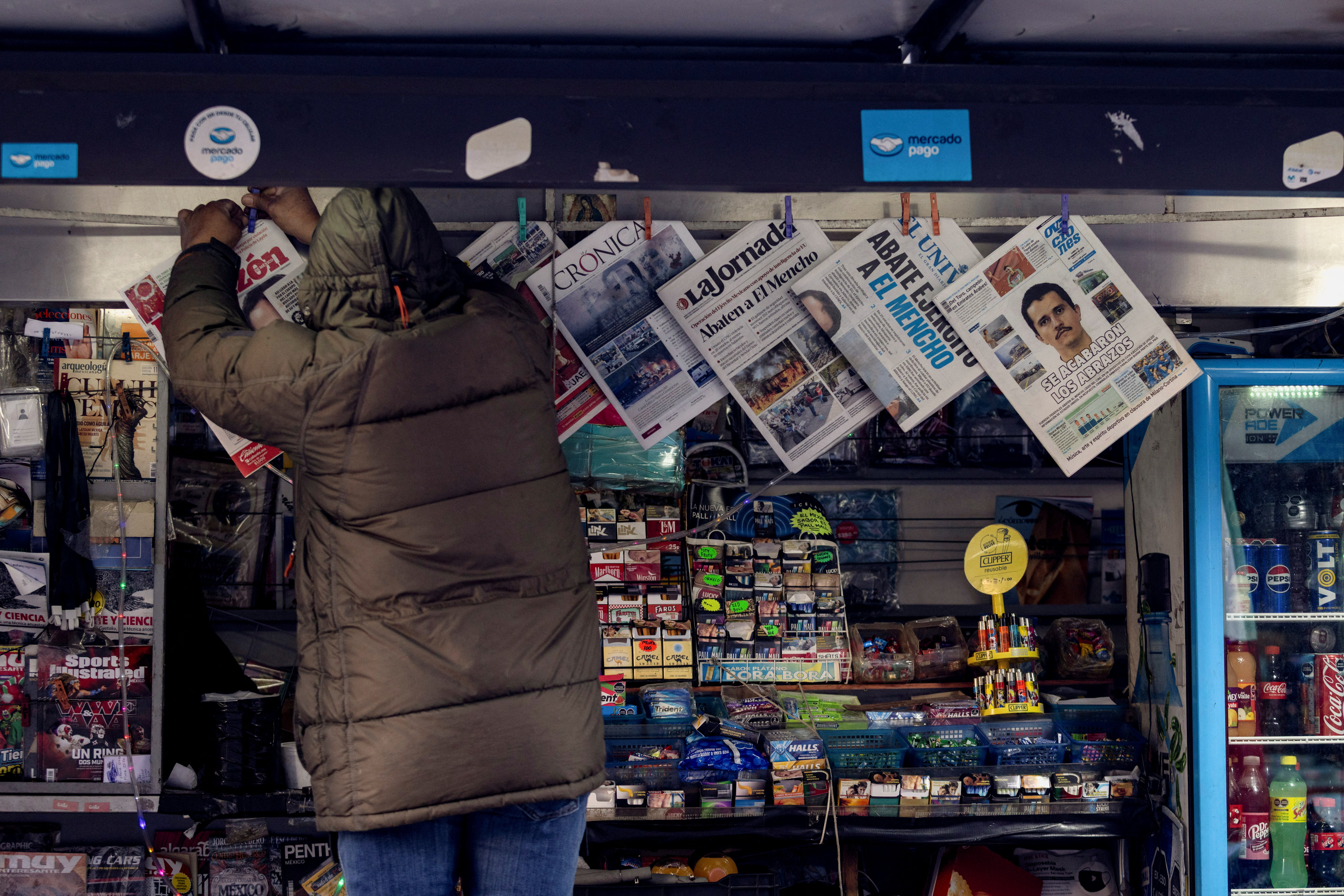 A newspaper seller arranges newspapers.
