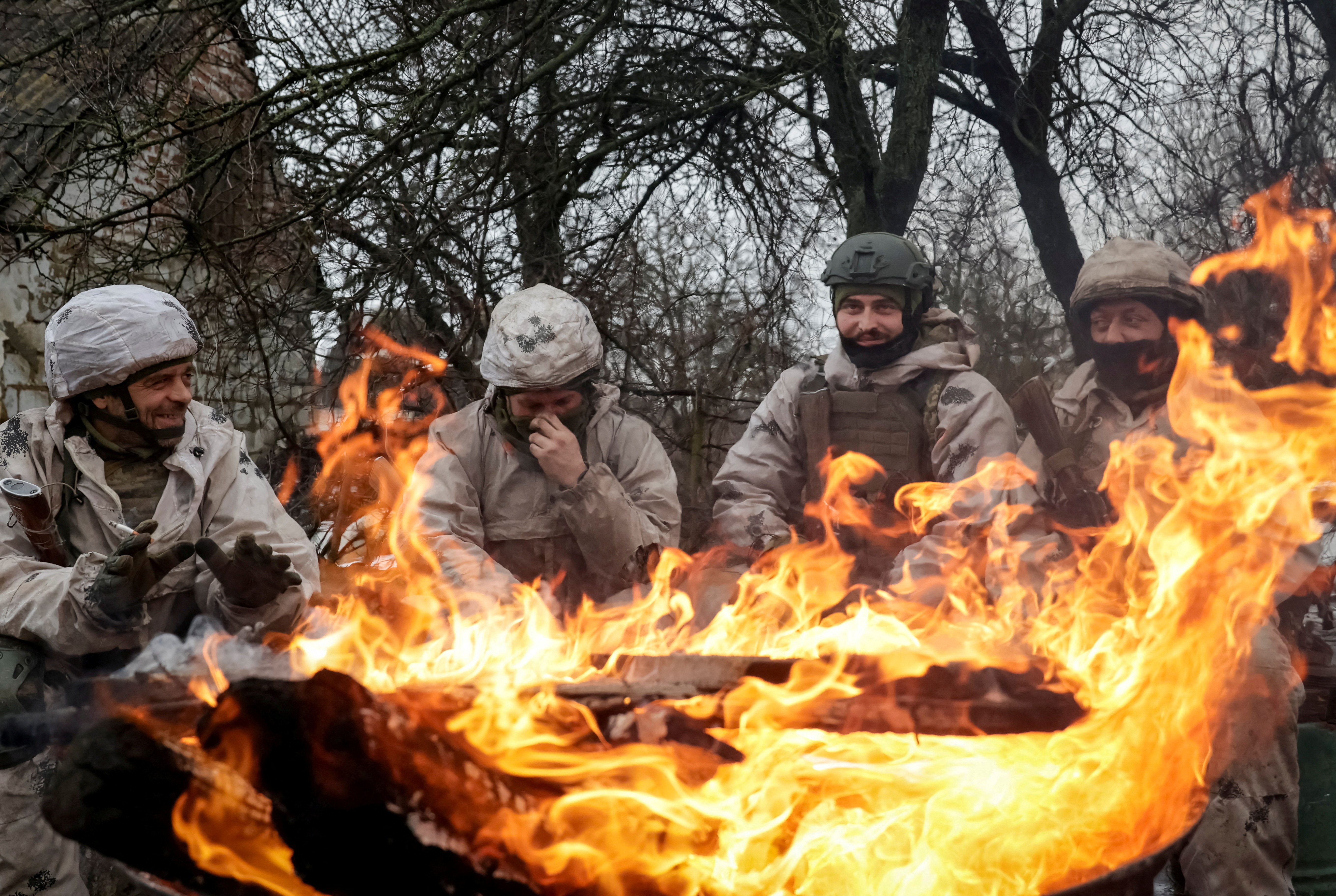 Recruits of the 28th Separate Mechanized Brigade of the Armed Forces of Ukraine warm themselves by the fire during a military exercise before combat missions, amid Russia's attack on Ukraine, in Kharkiv region, Ukraine February 26, 2026. REUTERS/Sofiia Gatilova TPX IMAGES OF THE DAY