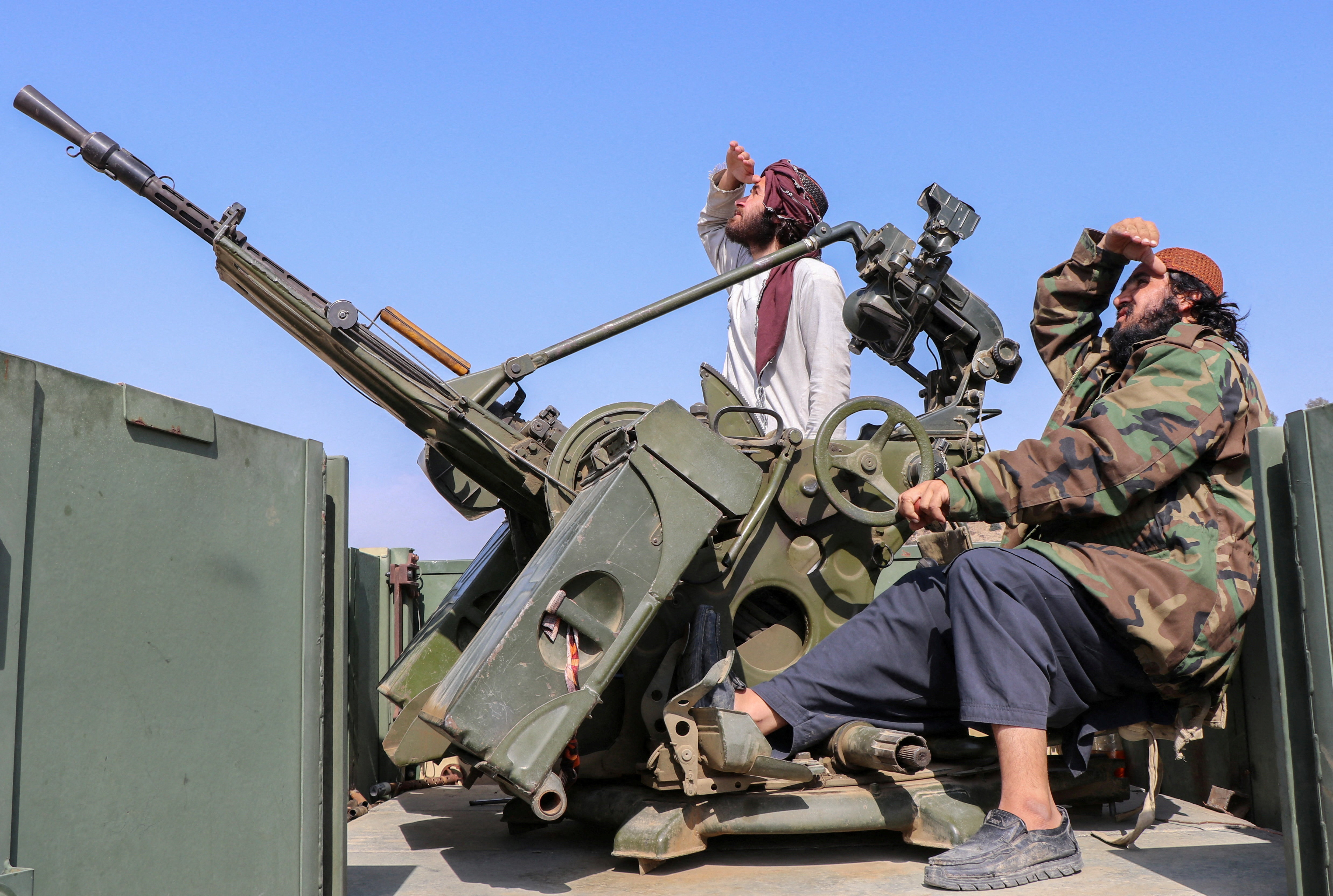 Taliban soldiers sit next to an anti-aircraft gun while on lookout for Pakistan's fighter jets, in Khost province, Afghanistan, February 27, 2026. REUTERS/Stringer TPX IMAGES OF THE DAY