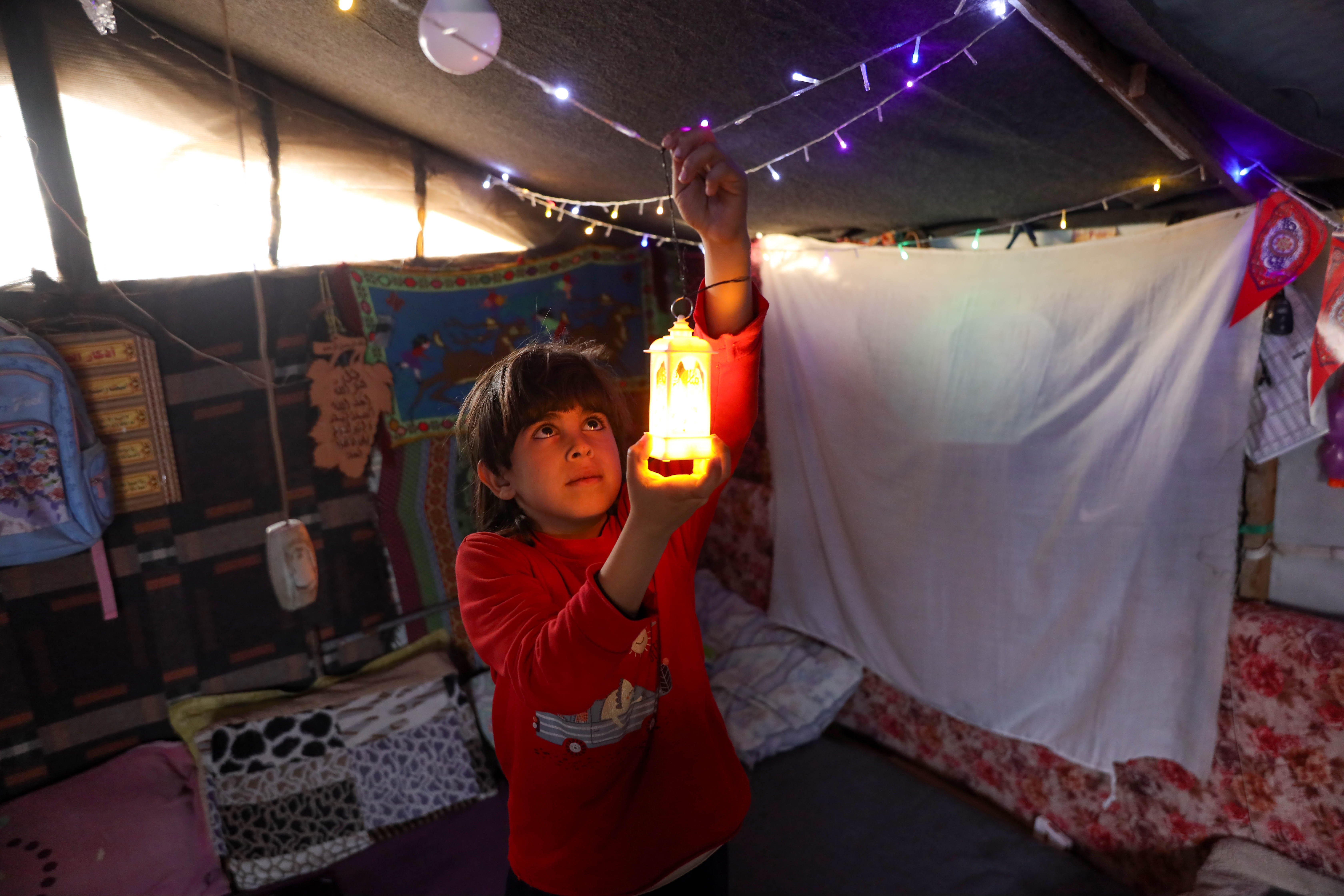 A boy hangs a lantern