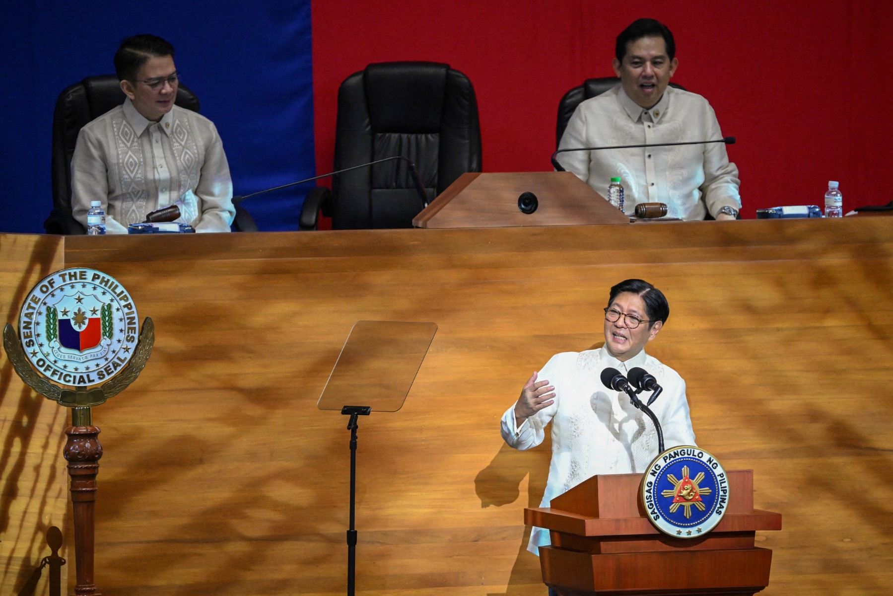 Philippine President Ferdinand Marcos delivers his speech in front of Senate President Chiz Escudero (L) and Speaker of the House Martin Romualdez (R) during the State of the Nation Address at the House of Representatives in Manila on July 28, 2025. (Photo by Ted ALJIBE / AFP)