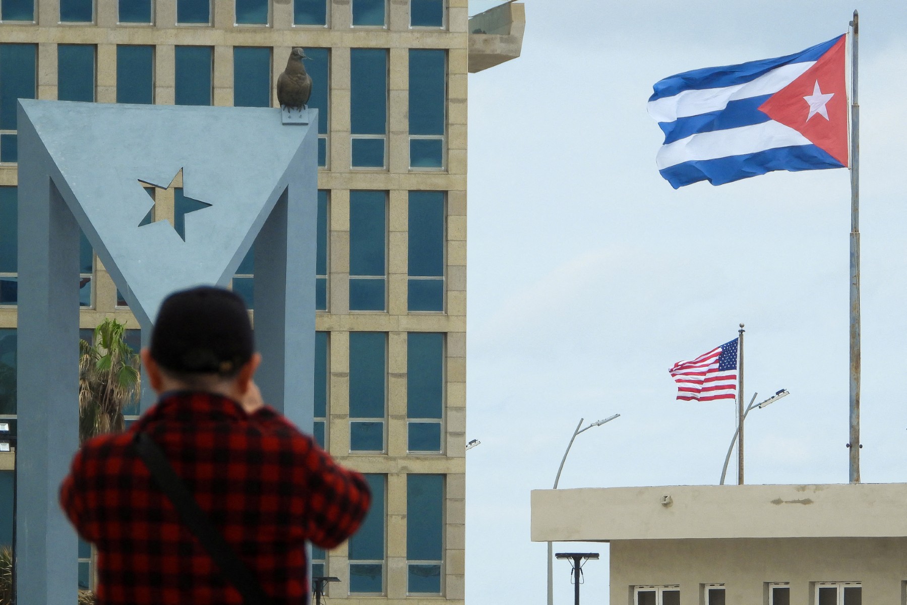 A tourist takes pictures of the US Embassy with the US flag and the Cuban flag in the background in Havana on January 30, 2026. Cuban President Miguel Diaz-Canel on January 30, 2026, denounced US President Donald Trump’s attempt to “asphyxiate” the communist island’s economy under a “false pretext.”