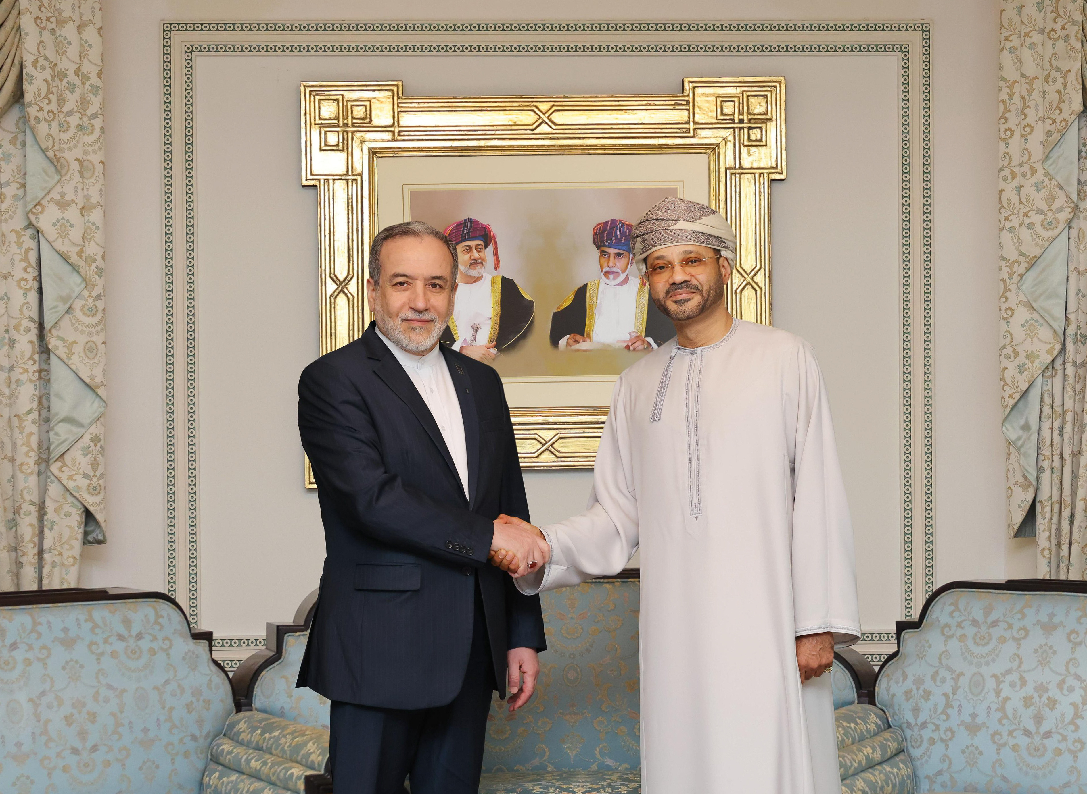 In this photo released by the Oman's Foreign Ministry, Iranian Foreign Minister Abbas Araghchi, left, shakes hands with his Omani counterpart Sayyid Badr Albusaidi during their meeting prior to Iran and the U.S. negotiations, in Muscat, Oman, Friday, Feb. 6, 2026. (Oman Foreign Ministry via AP)