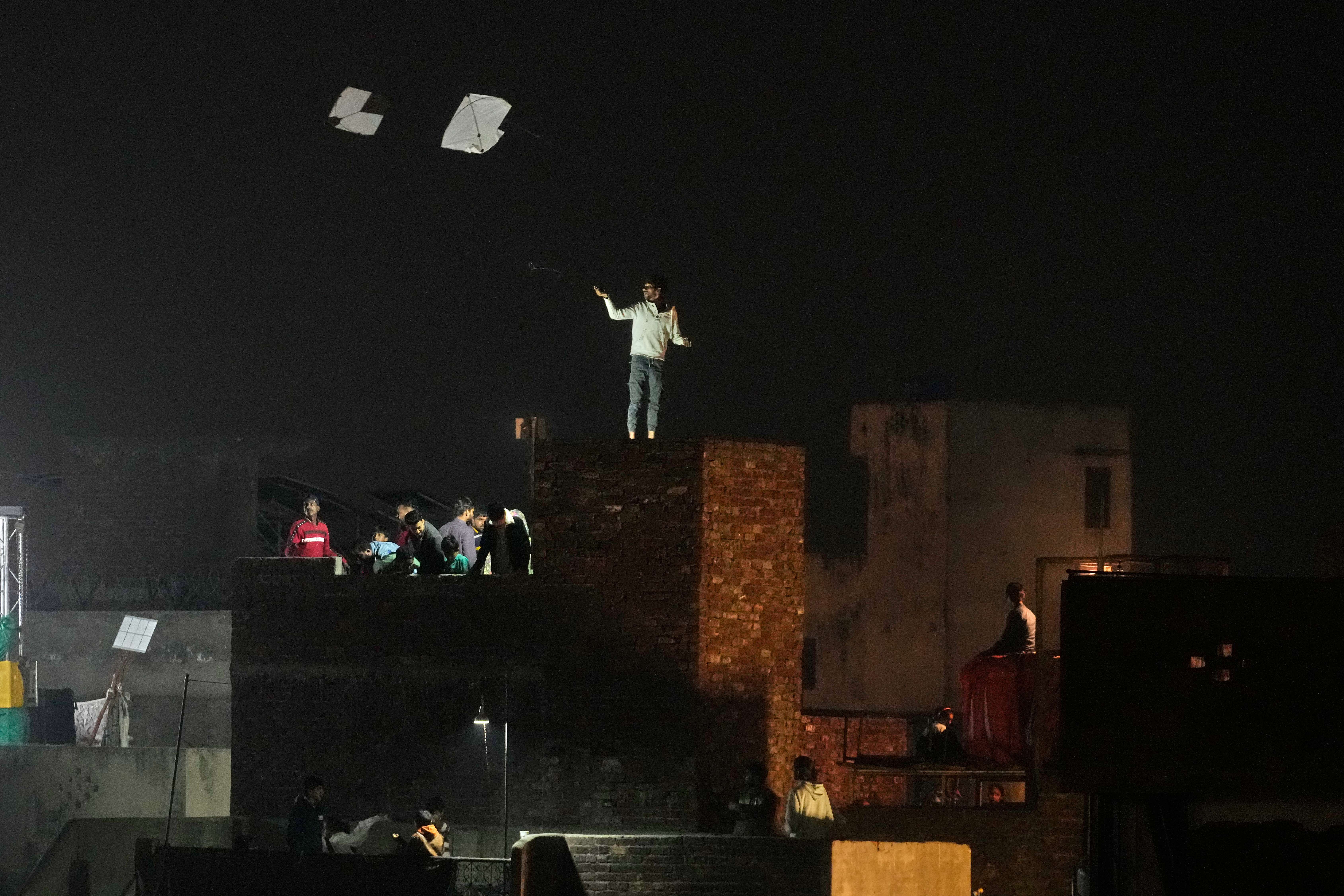 People gather on their decorated rooftops to celebrate the Basant kite flying festival in Lahore, Pakistan, late Friday, Feb. 6, 2026. (AP Photo/K.M. Chaudary)
