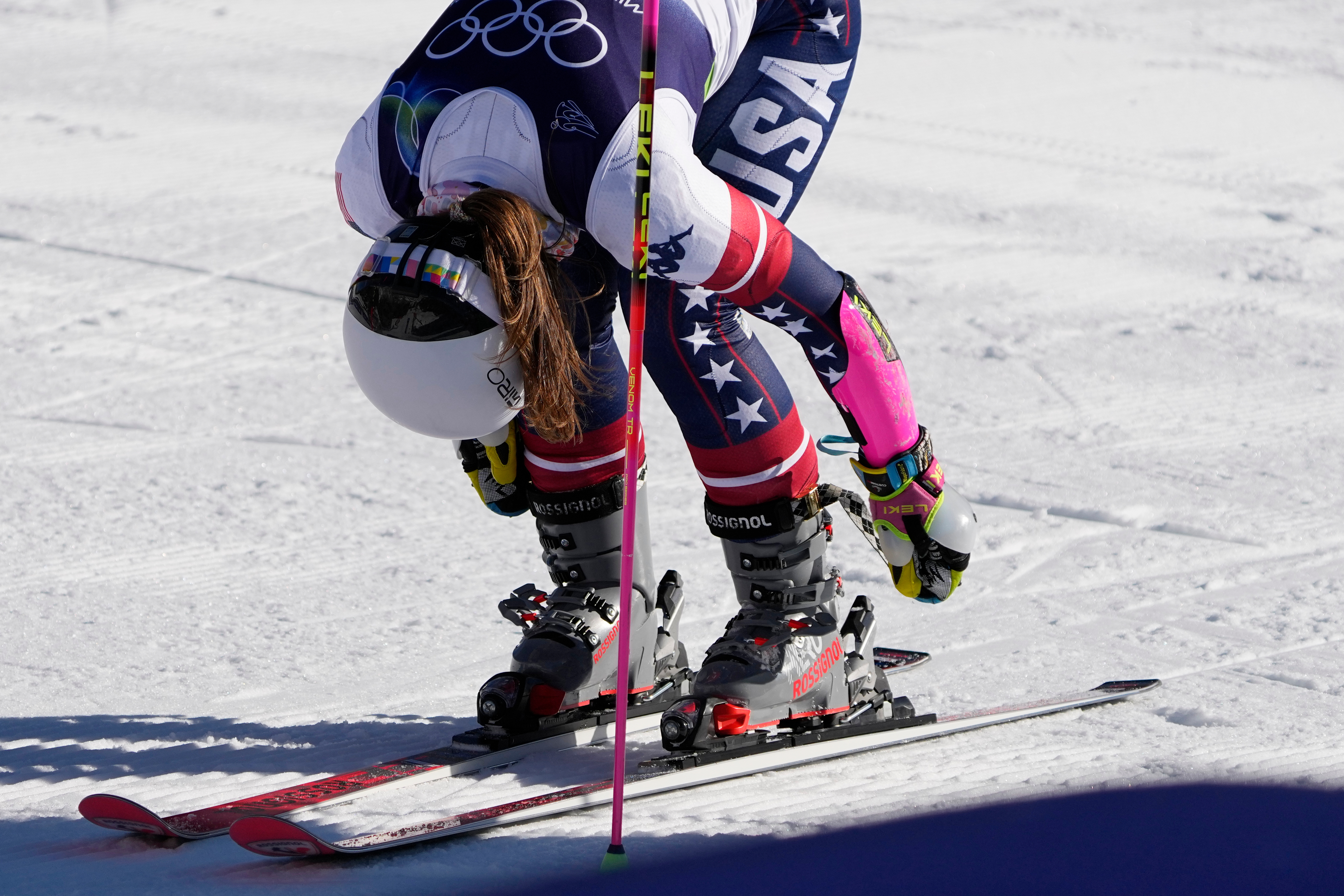 United States' Paula Moltzan unlatches her boots at the finish area of an alpine ski, women's giant slalom race, at the 2026 Winter Olympics