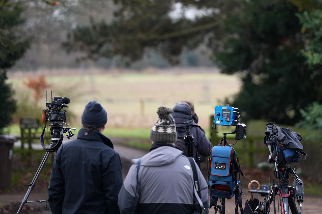 Journalists wait at the entrance gate of the Sandringham Royal Estate in Sandringham, England