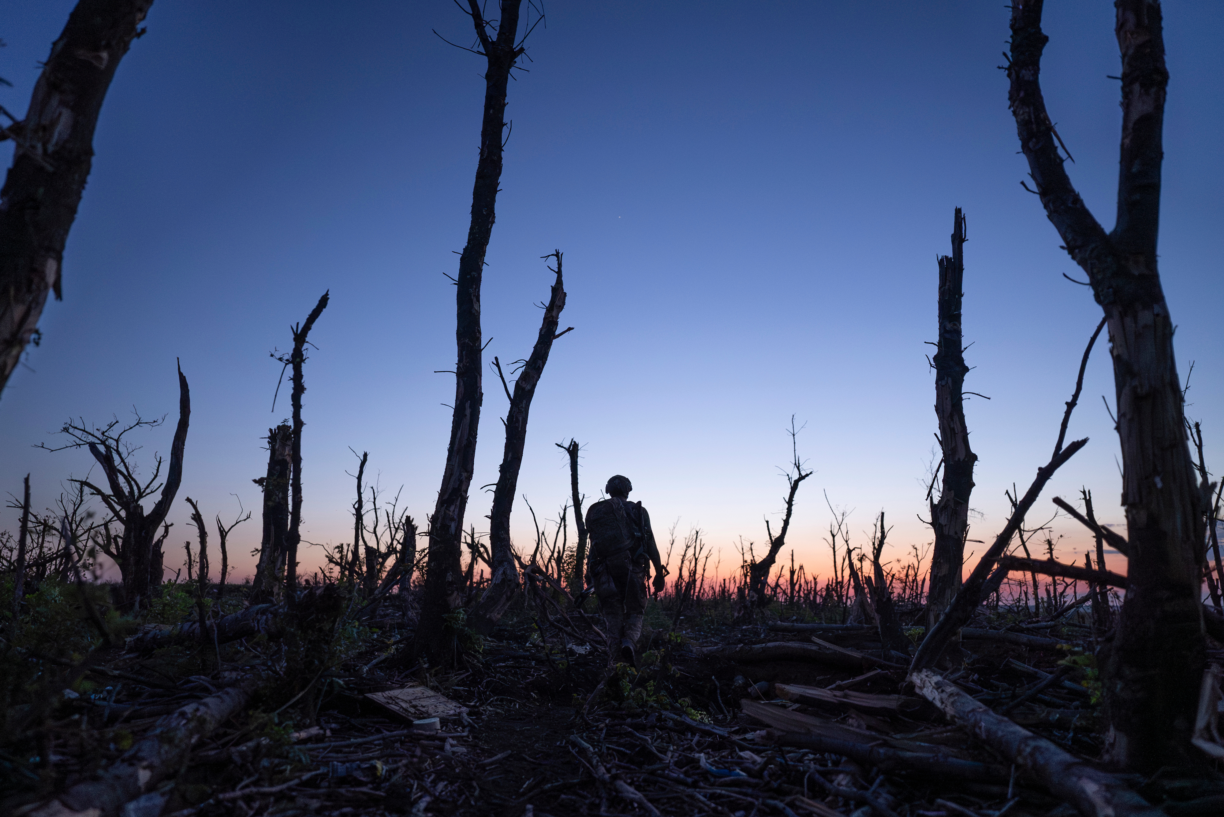 Ukrainian servicemen walk through a charred forest along the front line, a few kilometers from Andriivka, Donetsk region, Ukraine