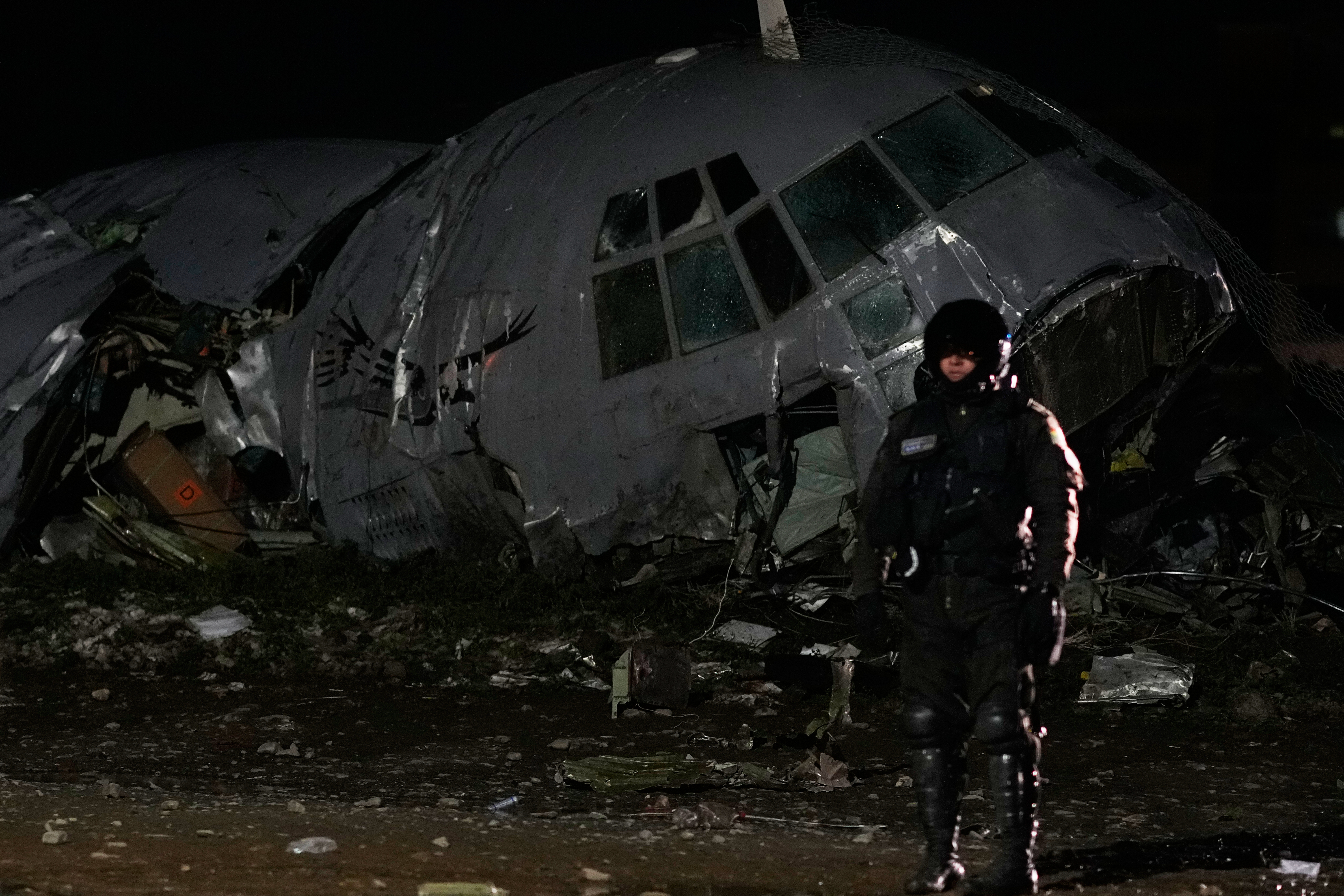 A military police stands next to a plane that crashed in El Alto, Bolivia, Friday, Feb. 27, 2026. (AP Photo/Juan Karita)