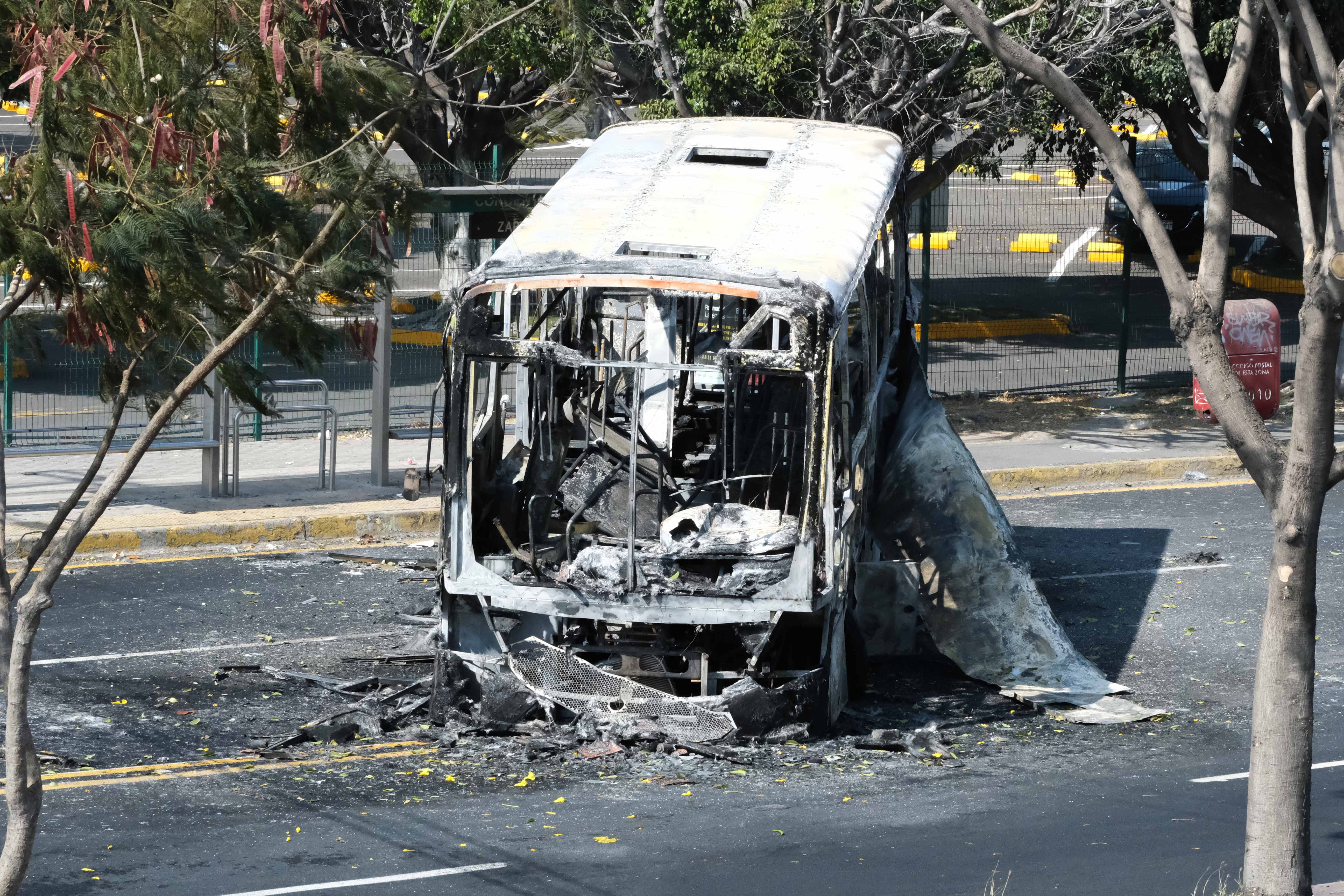 A burnt bus blocks the highway to Estadio Akron in Zapopan, Jalisco, Mexico on February 22, 2026. [Casey Premoshis/Al Jazeera]