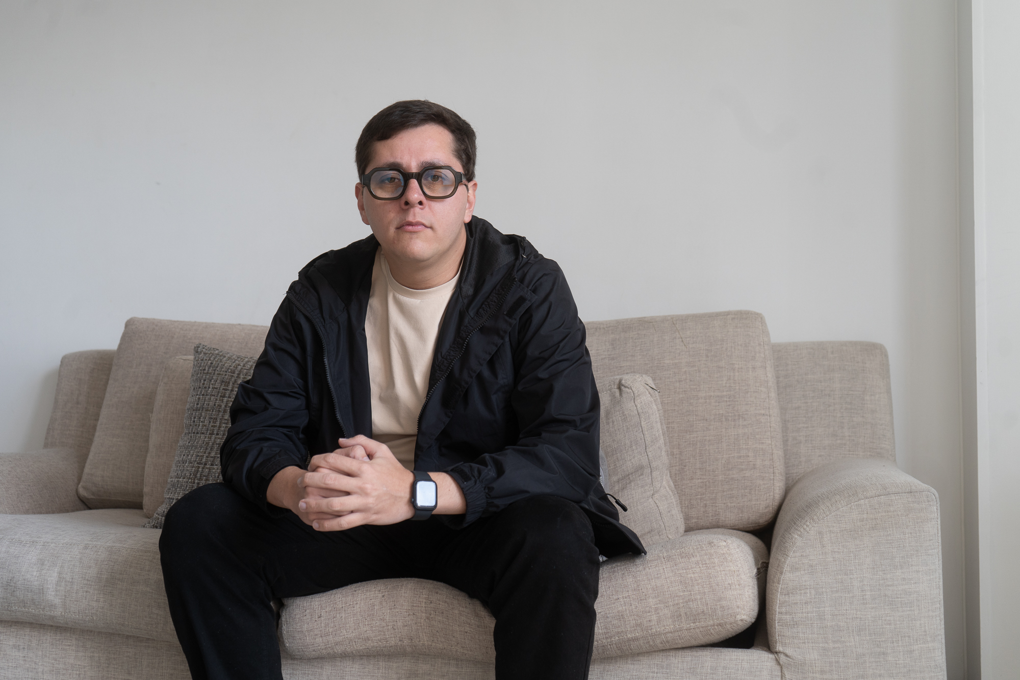 Luis Peche sits on a couch in Bogota