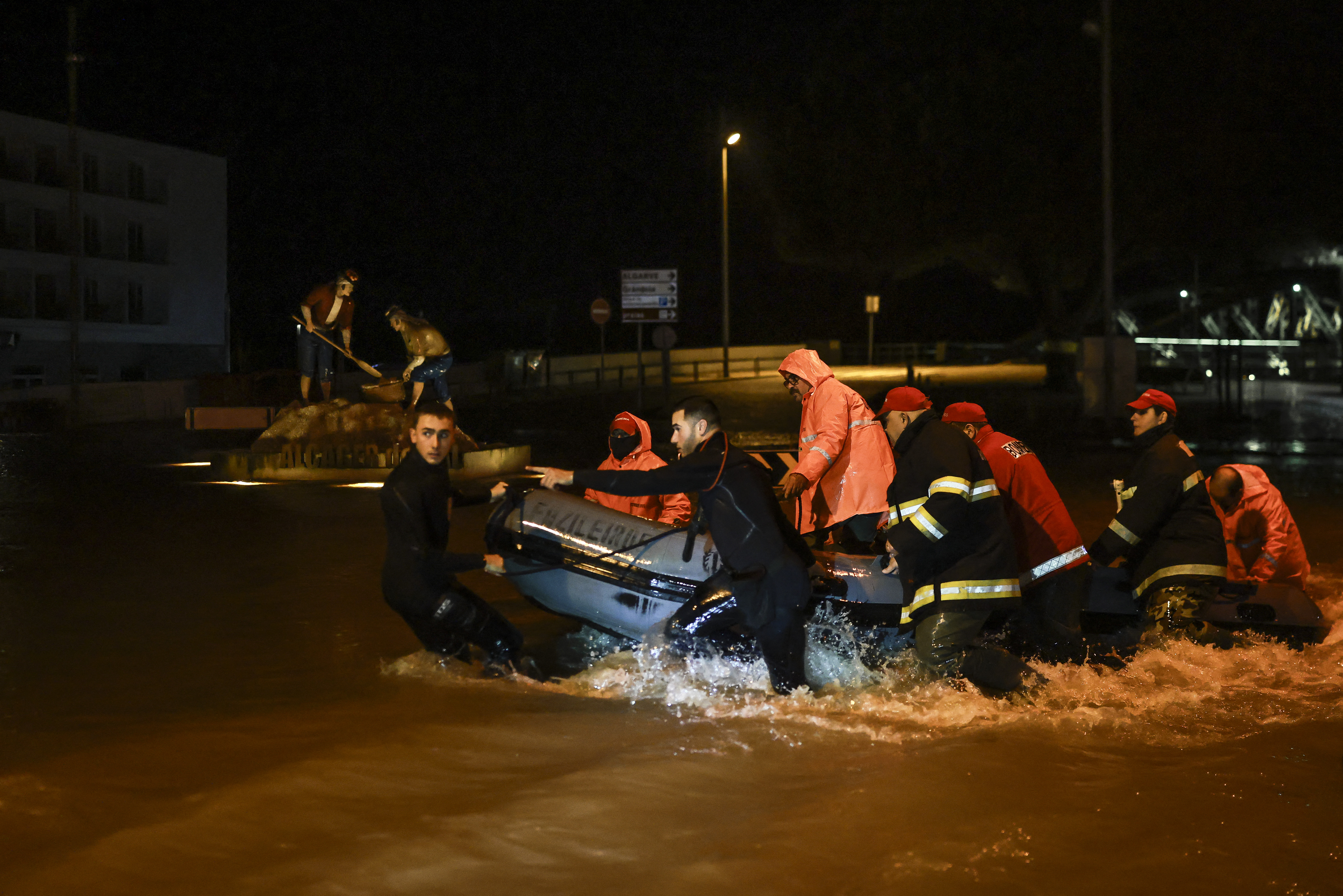 TOPSHOT - Firefighters pull an inflatable boat as floodwaters from Sado River cover the streets in Alcacer do Sal, south of Portugal, amid Storm Leonardo on February 4, 2026.