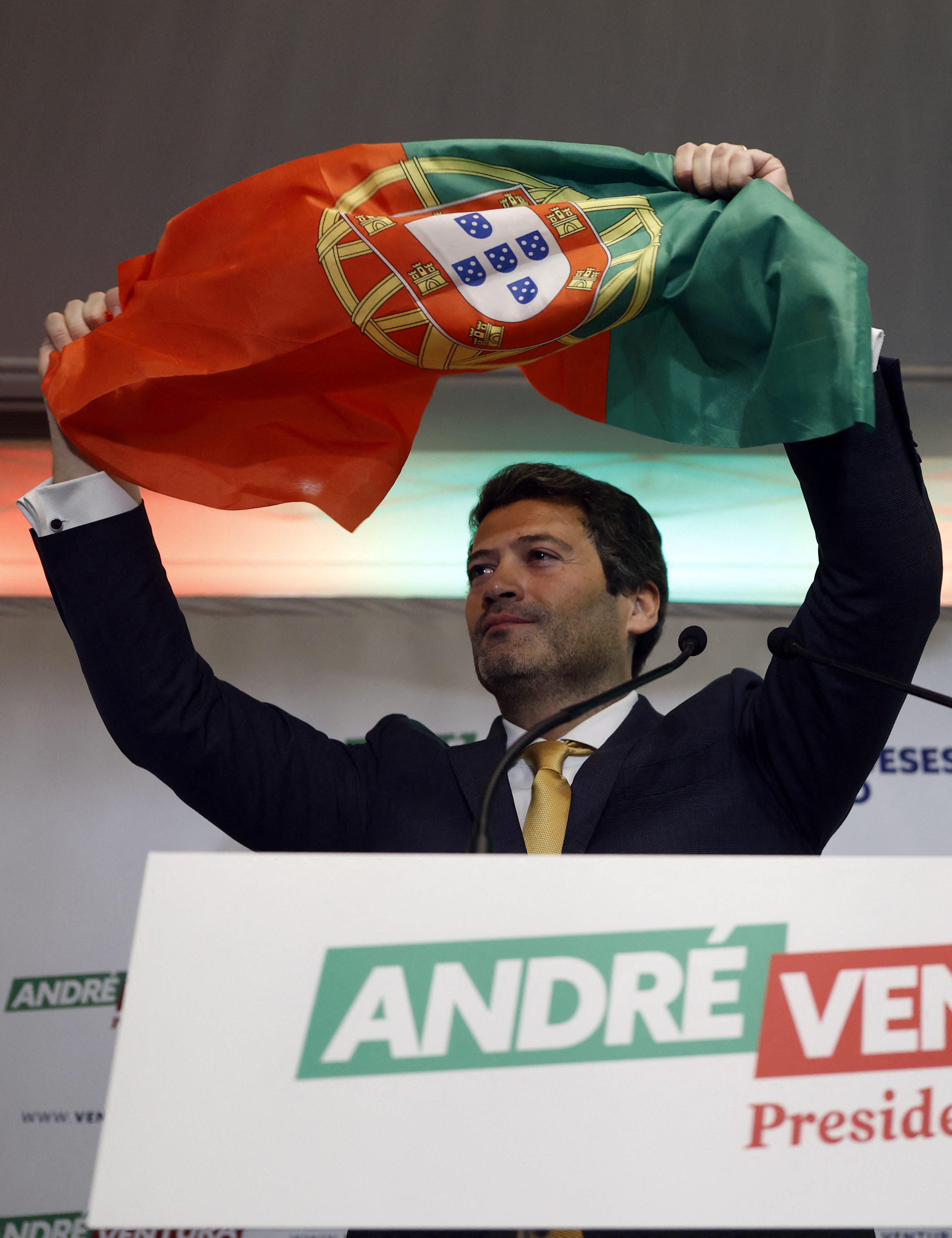 (FILES) The leader of Chega (Enough) party, far-right candidate Andre Ventura waves a Portuguese flag as he addresses supporters on the night of Portugal's presidential election first round in Lisbon on January 18, 2026.