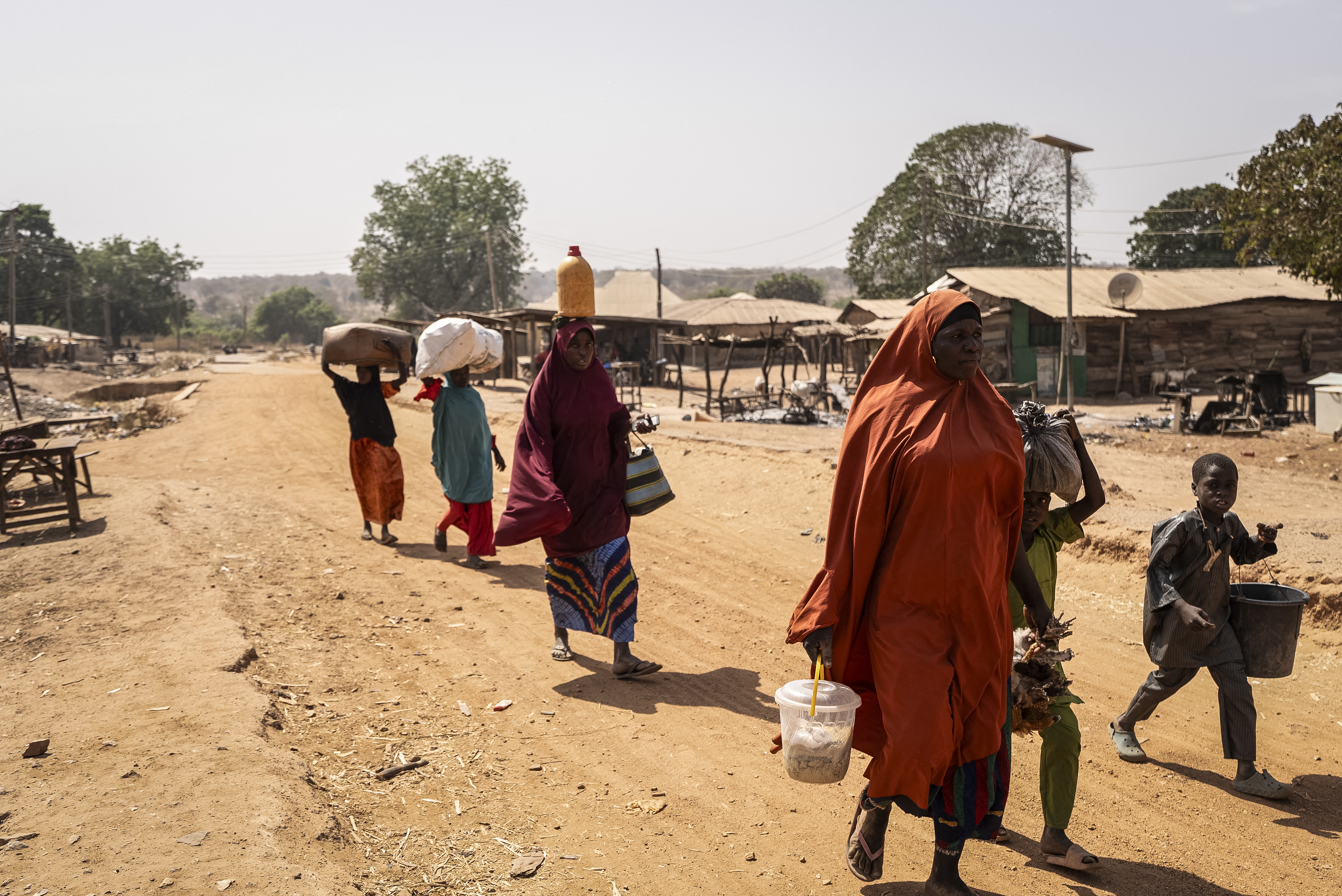 Residents carry their belongings as they flee the area following the attack in Woro, Kwara State, on February 5, 2026.