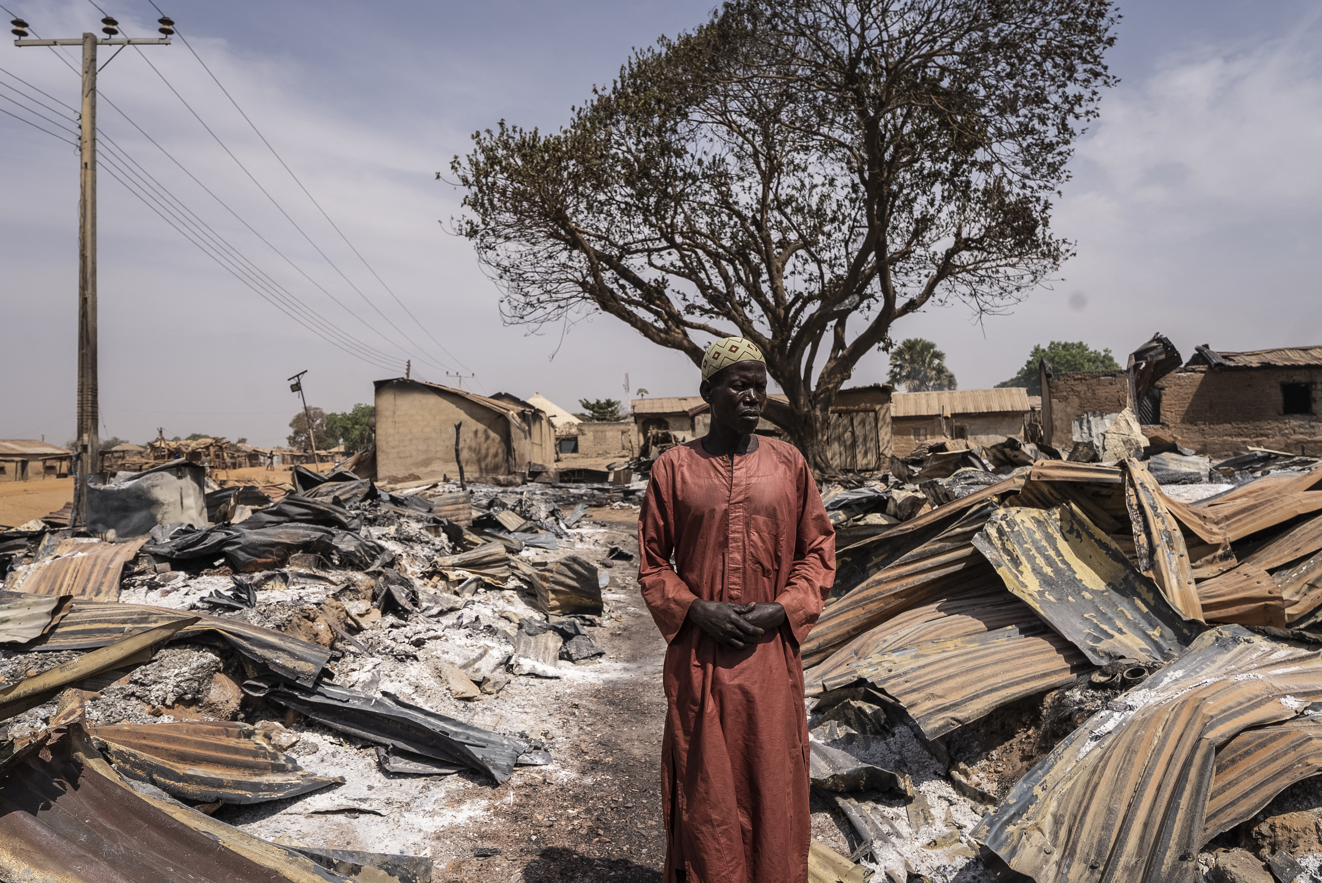 TOPSHOT - A resident stands among burnt debris and damaged homes following the attack in Woro, Kwara State, on February 5, 2026.