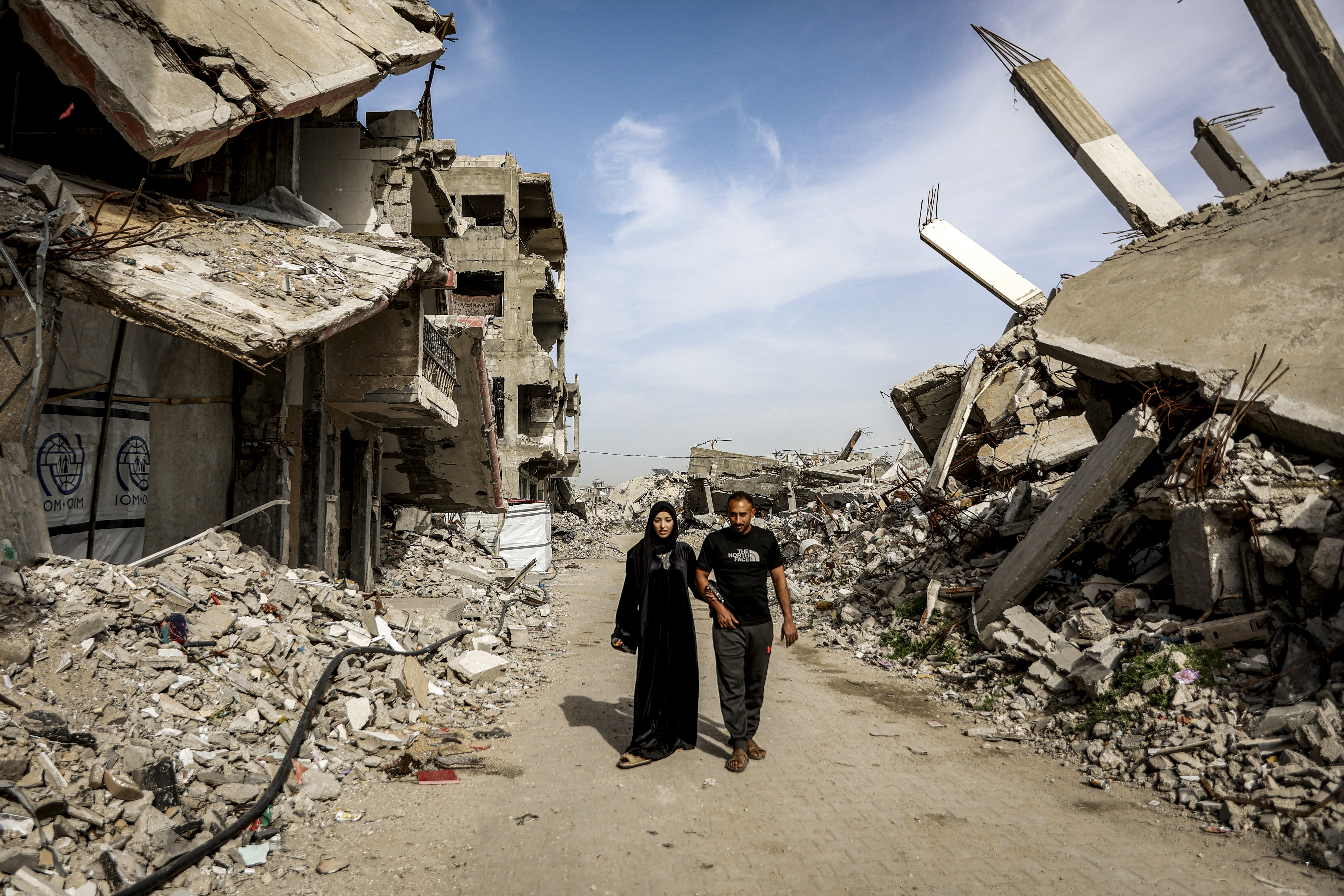 Etedal Rayyan (29), who recently returned back to Gaza from Egypt through the Rafah border crossing, walks with and her husband past the rubble of destroyed buildings in the Jabalia camp for Palestinian refugees in the northern Gaza Strip on February 8, 2026.