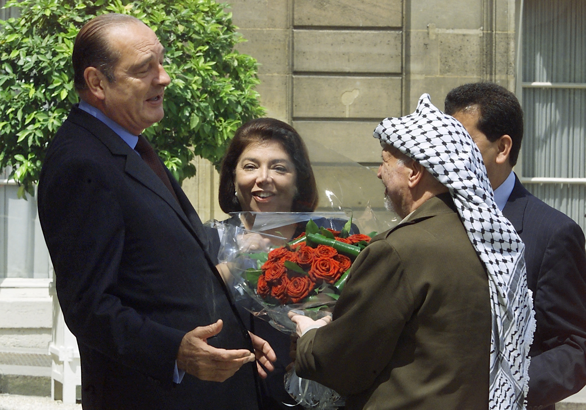 (FILES) Palestinian Authority President Yasser Arafat (R), next to Palestine's general delegate in France, Leila Shahid (C), offers flowers to French President Jacques Chirac on July1, 2000 at his arrival at the Elysee Palace in Paris.