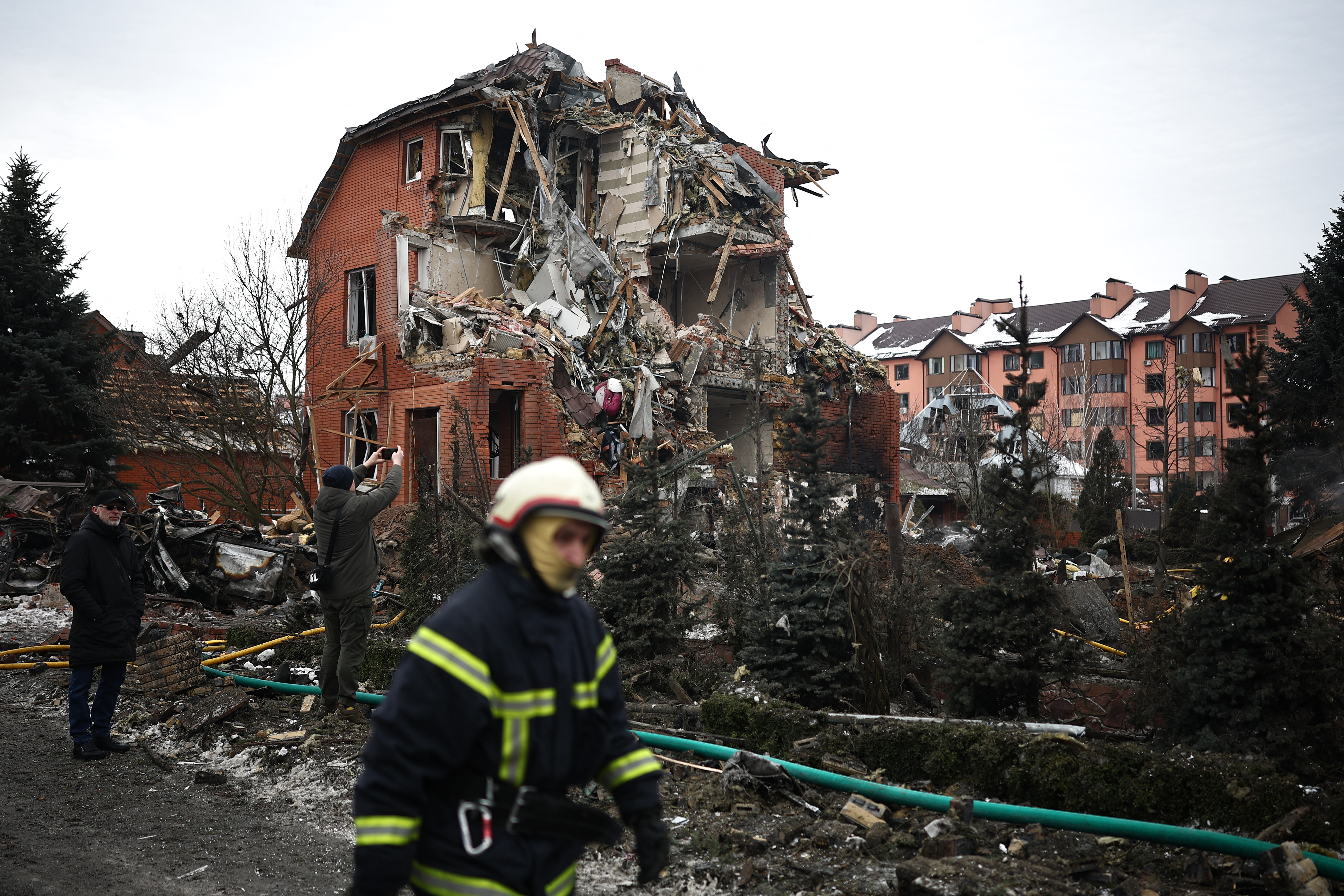 A Ukrainian rescuer walks past a heavily damaged house following an air attack in Sofiivska Borshchagivka, Kyiv region on February 22, 2026, amid the Russian invasion of Ukraine.
