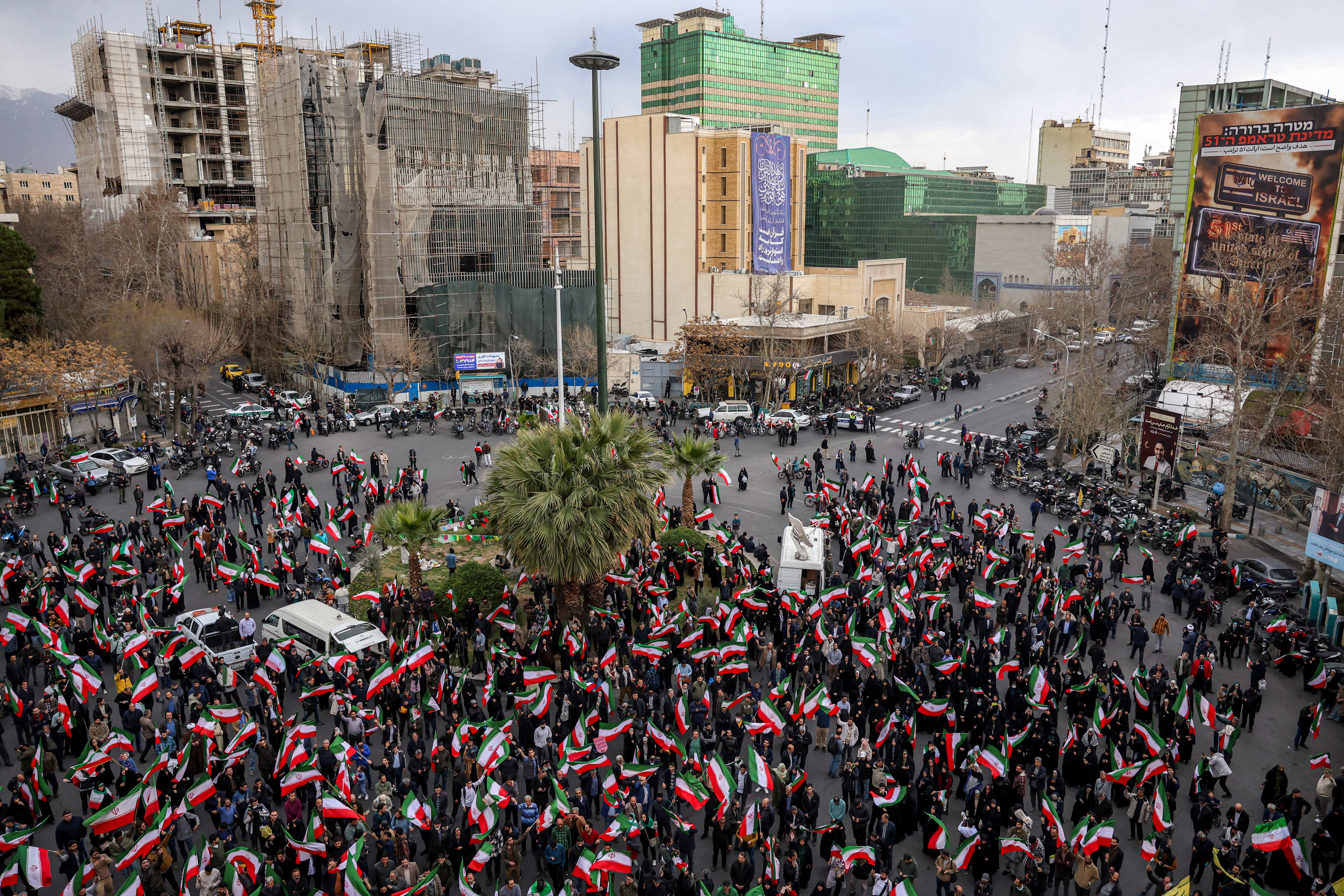 Protesters gather with Iranian national flags during a demonstration in support of the government and against US and Israeli strikes outside a mosque in Tehran on February 28, 2026.