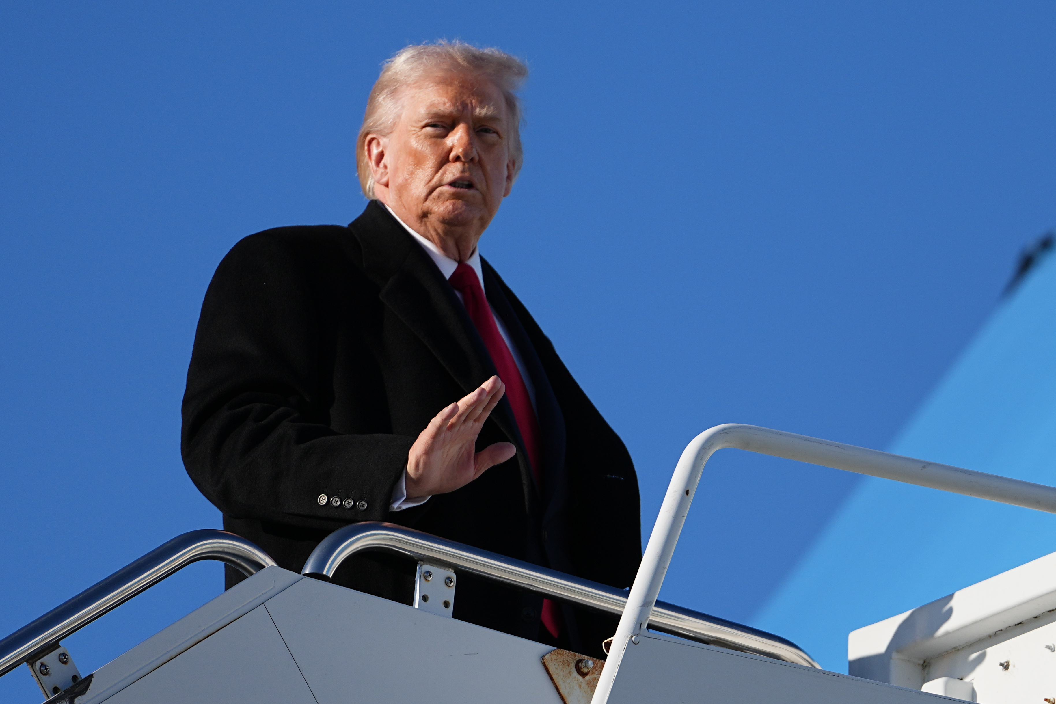 President Donald Trump waves as he boards Air Force One at Pope Army Airfield, in Fort Bragg, N.C., Friday, Feb. 13, 2026, en route to Palm Beach, Fla. (AP Photo/Matt Rourke)