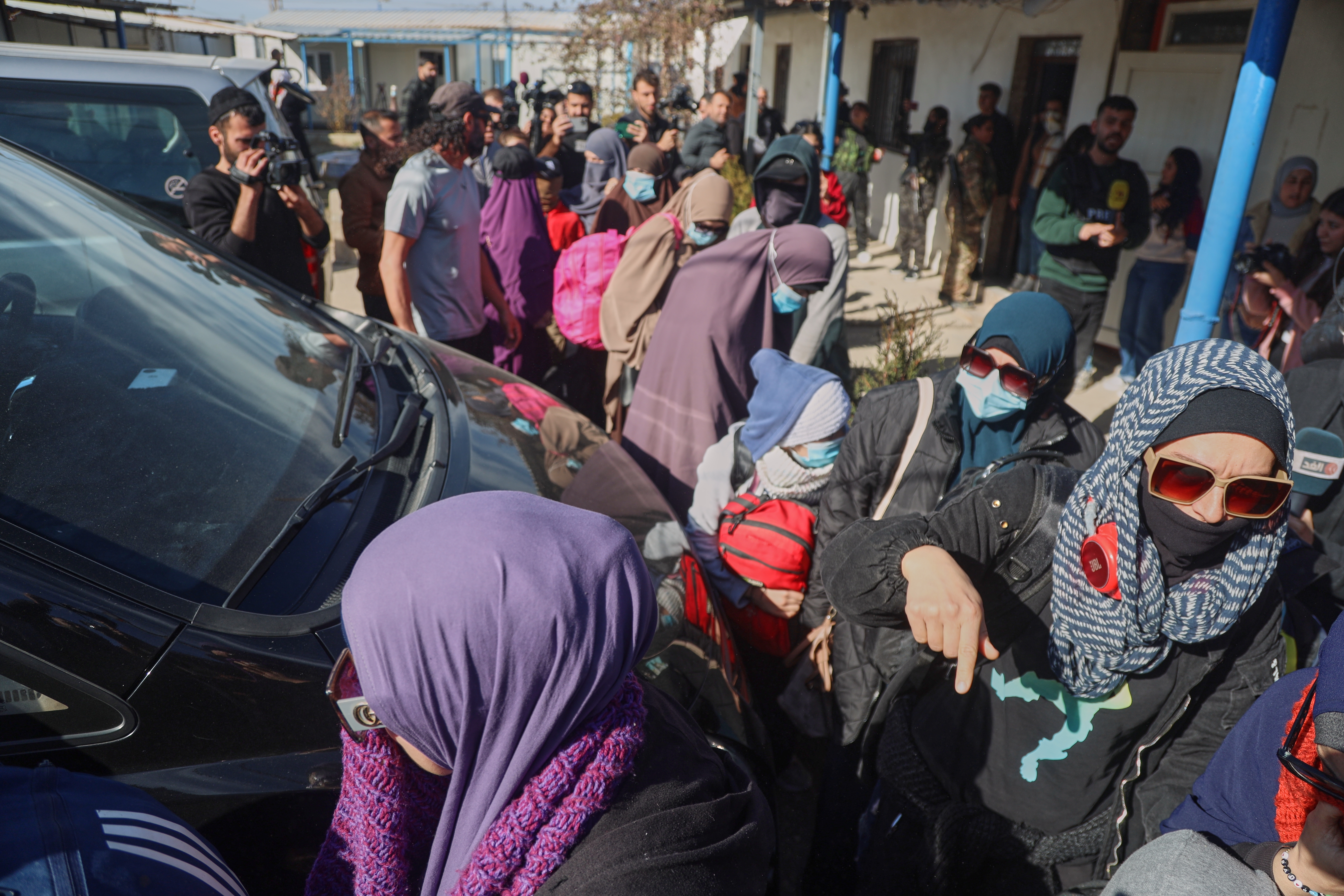 Family members of suspected Islamic State militants who are Australian nationals walk toward a van bound for the airport in Damascus during the first repatriation operation of the year at Roj Camp in eastern Syria, Monday, Feb. 16, 2026. Thirty-four Australian citizens from 11 families departed the camp. (AP Photo/Baderkhan Ahmad)