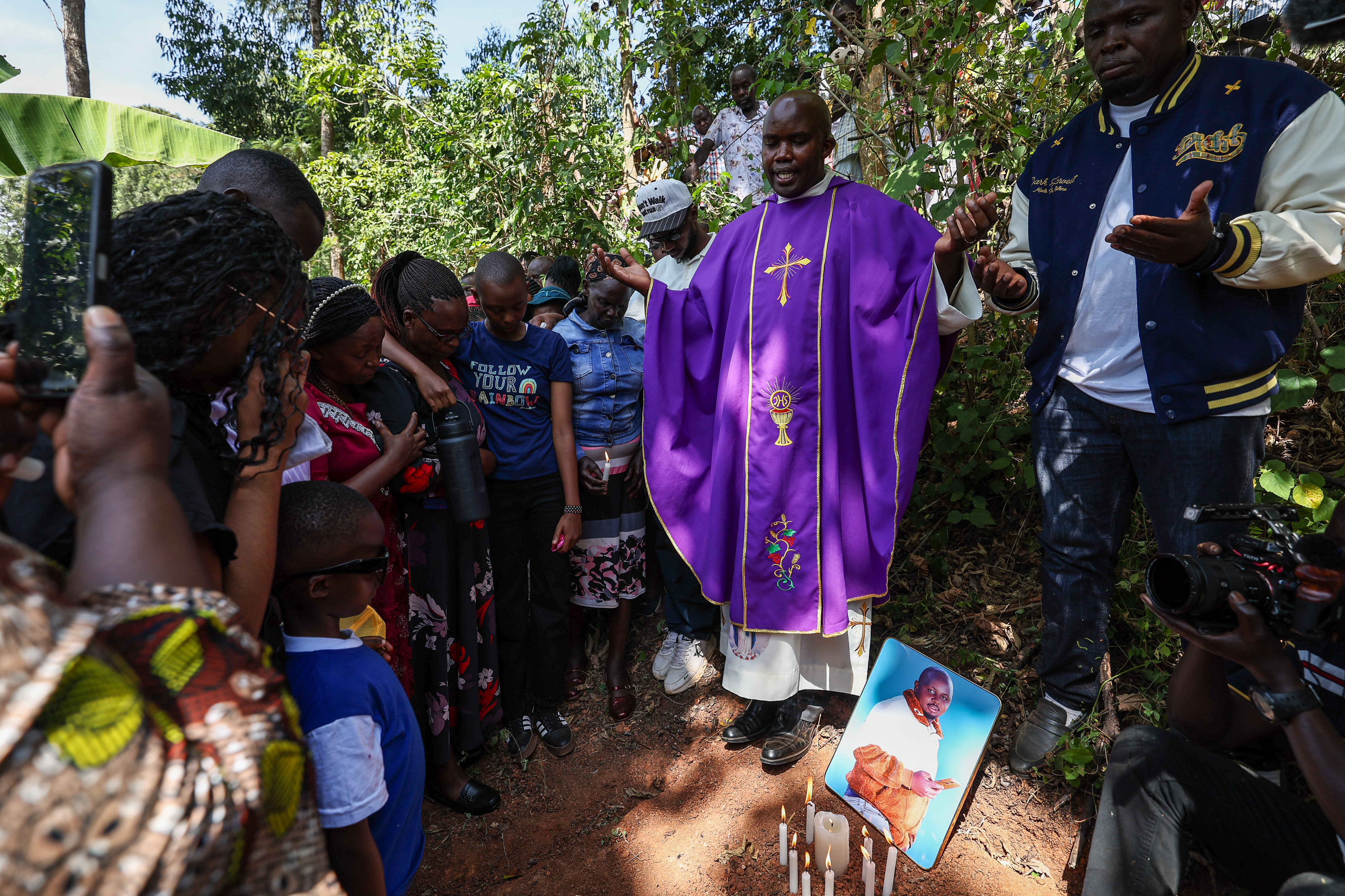 epa12707173 A Catholic priest (C) leads a prayer during a symbolic funeral service of Charles Waithaka Wangari 31yrs, who was killed while fighting in Russia, next to a symbolic grave after failing to retrieve his body from Russia for burial at their rural Mukurwe-ini village, in Nyeri, Kenya, 05 February 2026. Waithaka is among the many Kenyans and other African youths who have fallen victims after being lured for lucrative jobs in Russia but later are forcefully recruited into the Russian military to fight against Ukraine Army in the frontline in the ongoing Ukraine-Russia war. According to a briefing from Kenya’s Ministry of Foreign and Diaspora Affairs of November 2025, recruitment exercises in Russia have reportedly expanded to include African nationals, including Kenyans since the start of the conflict between Russia and Ukraine in 2022. Reports suggest that over two hundred Kenyans may have joined the Russian military after being lured by promises of ordinary jobs, only to end up on the frontline in Ukraine. EPA/DANIEL IRUNGU