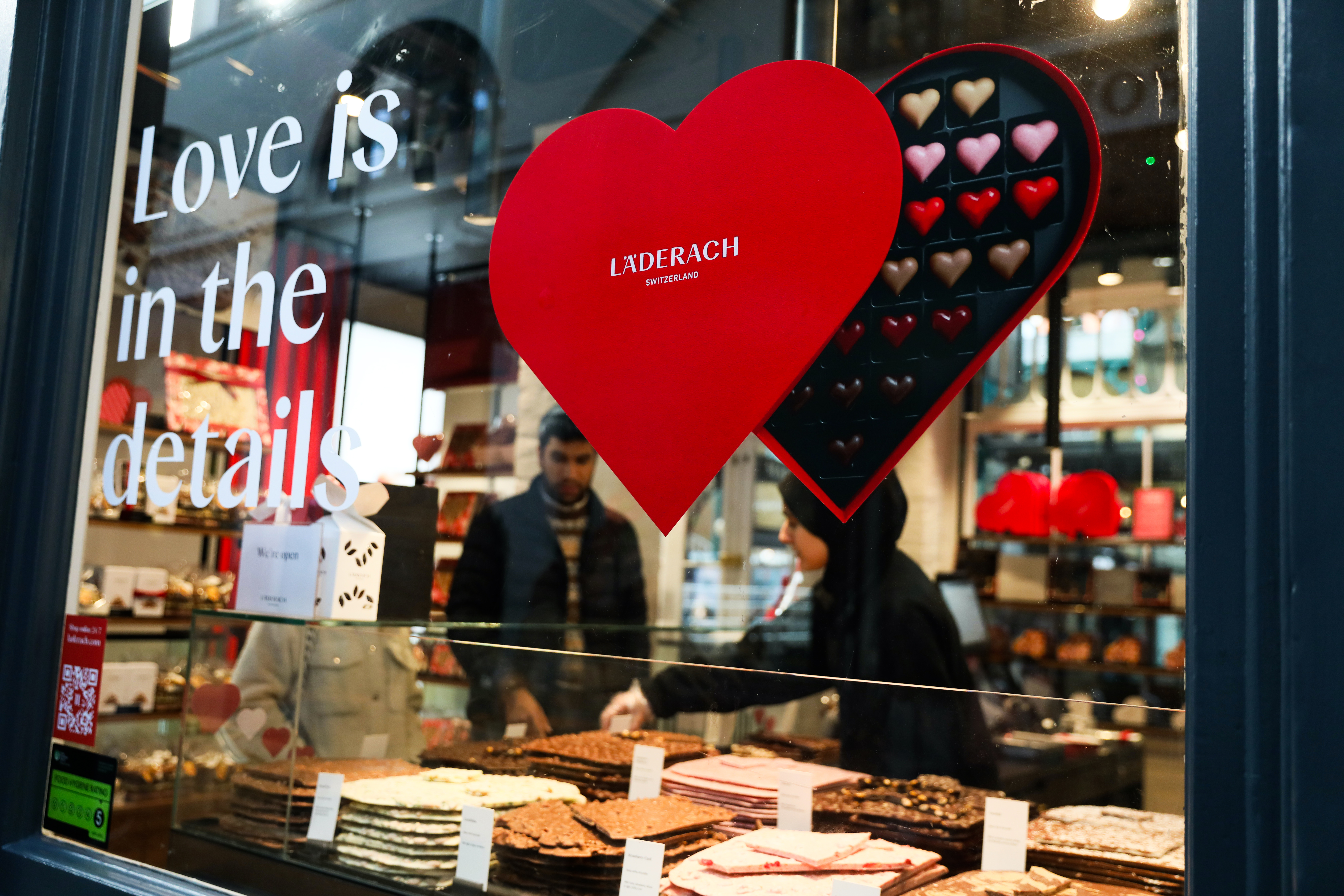 LONDON, ENGLAND - FEBRUARY 14: A couple purchase Valentine's Day chocolate in Covent Garden on February 14, 2025 in London, England. Londoners are spending an average of £69 on their loved ones this Valentine's Day. 72% of couples in the city are planning to celebrate, and a quarter of those are heading out for a meal. The most popular gifts are flowers, food and drink. (Photo by Alishia Abodunde/Getty Images)