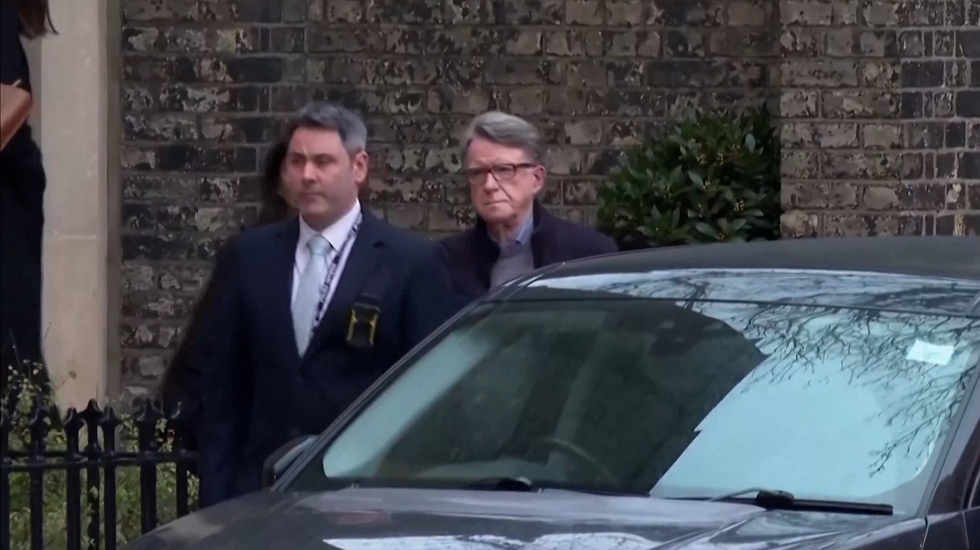 Police lead Peter Mandelson to a waiting car upon his arrest on February 23, 2026. [Screenshot via Reuters]