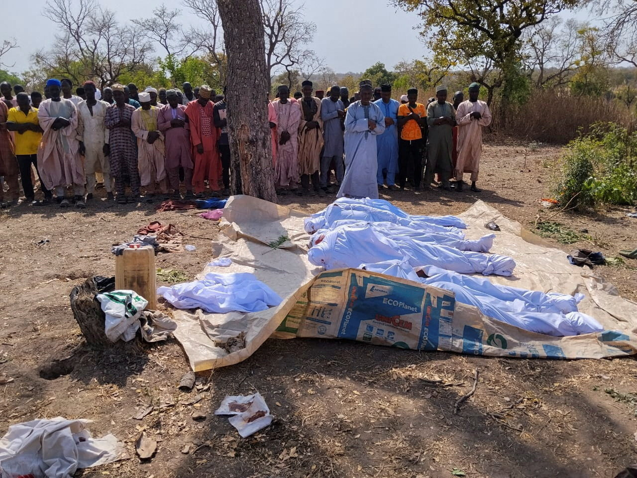 People pray beside the bodies of victims of a terror attack before their burial at Woro community, after an overnight attack by gunmen that killed dozens of residents, in Kaiama Local Government Area of Kwara State, Nigeria, February 4, 2026. REUTERS/Oluseyi Dasilva TPX IMAGES OF THE DAY