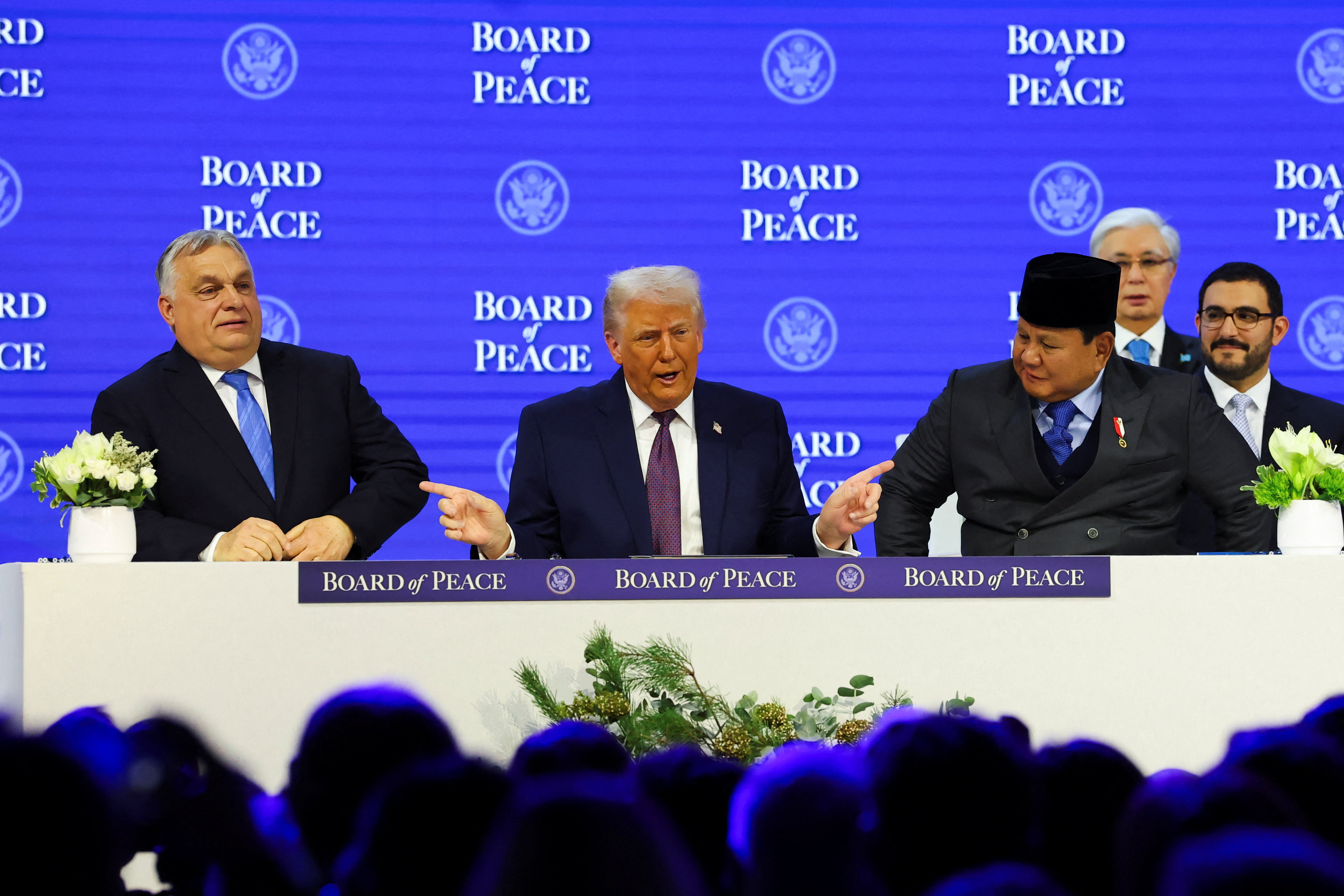 U.S. President Donald Trump gestures towards Hungary's Prime Minister Viktor Orban and Indonesia's President Prabowo Subianto, as they take part in a charter announcement for his Board of Peace initiative aimed at resolving global conflicts, alongside the 56th annual World Economic Forum (WEF), in Davos, Switzerland, January 22, 2026. REUTERS/Denis Balibouse