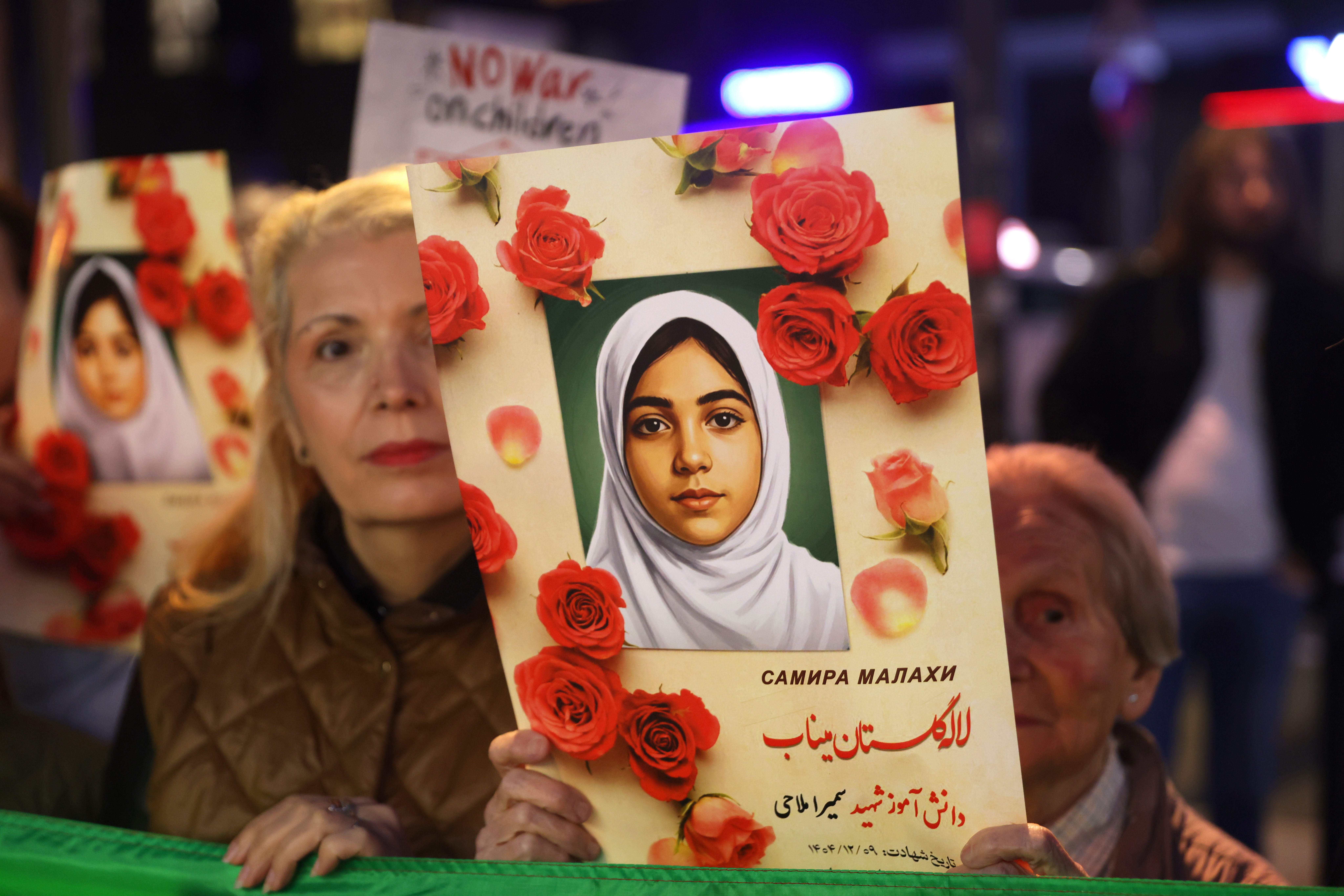 A protester holds a photograph of a young girl reported killed in the bombing of a primary school in Minab, Iran, during a solidarity rally in Belgrade, Serbia