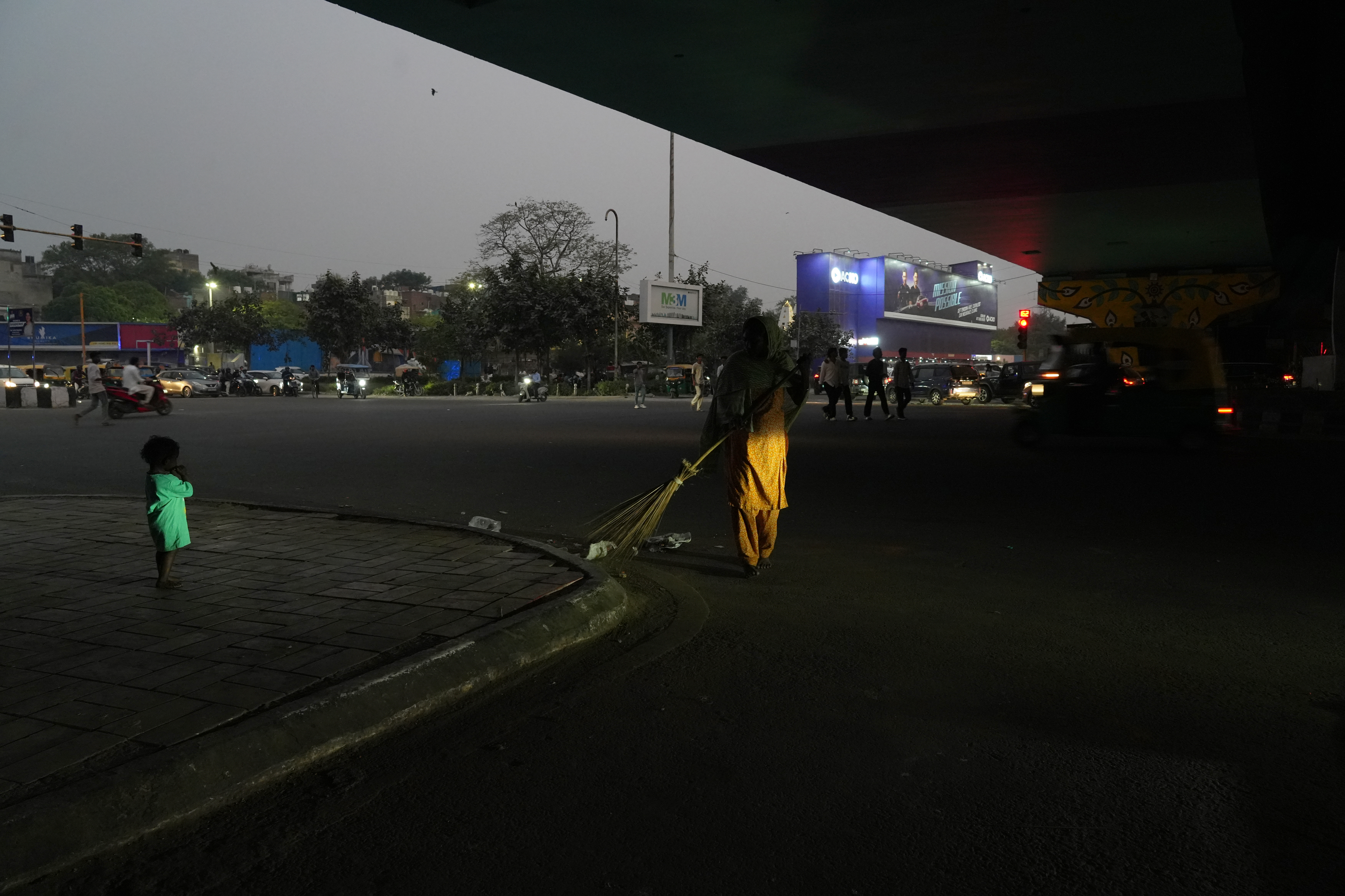 Abida, 40, lies on a charpai with her three children under a flyover in Delhi,