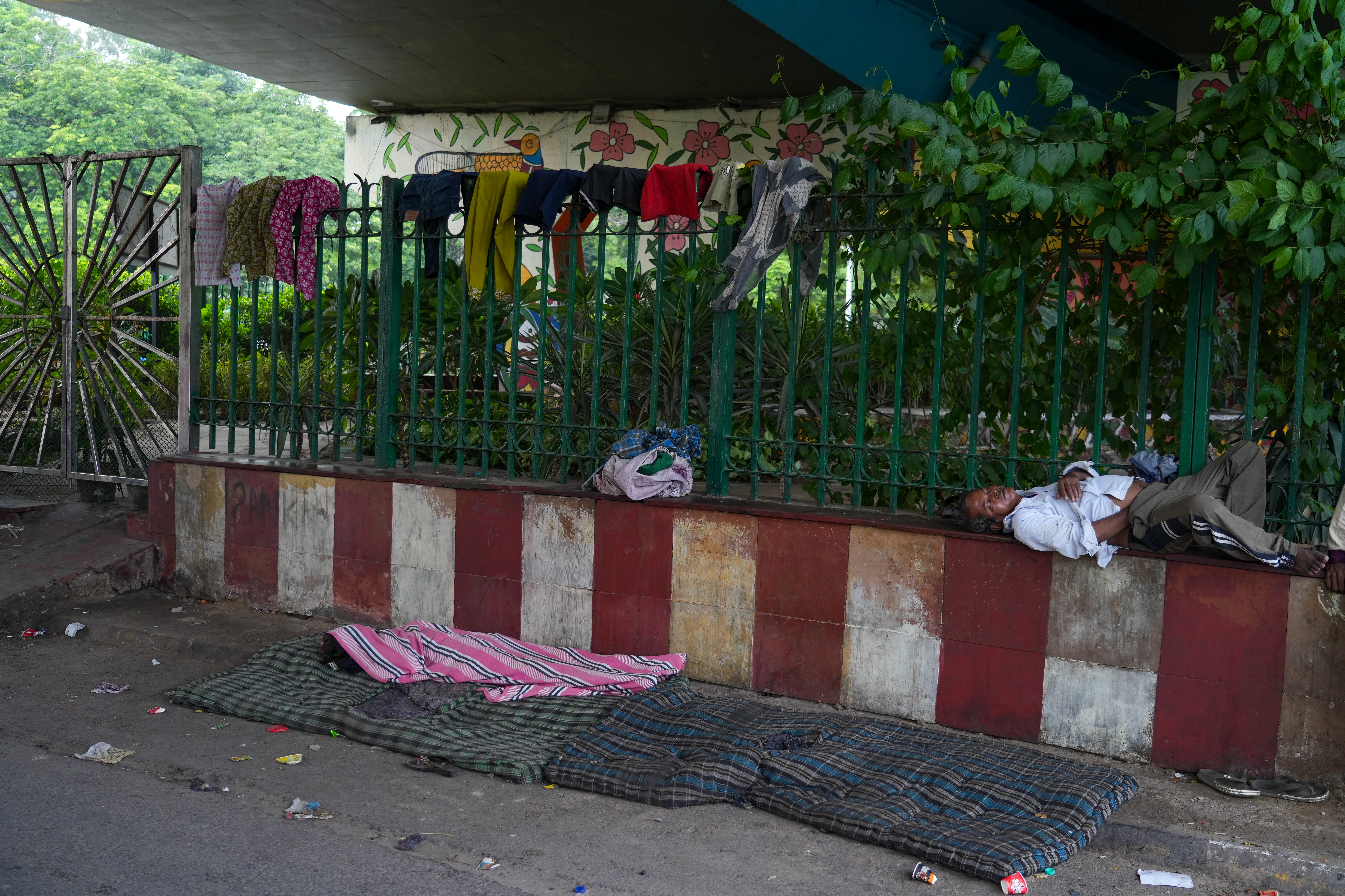 A small park with grills is where Abida dries their clothes.She says that even when the clothes dry, a layer of dust remains on them. No matter how much they clean themselves or their clothes, they get dirty again within minutes. [Mubashir Naik/Al Jazeera]