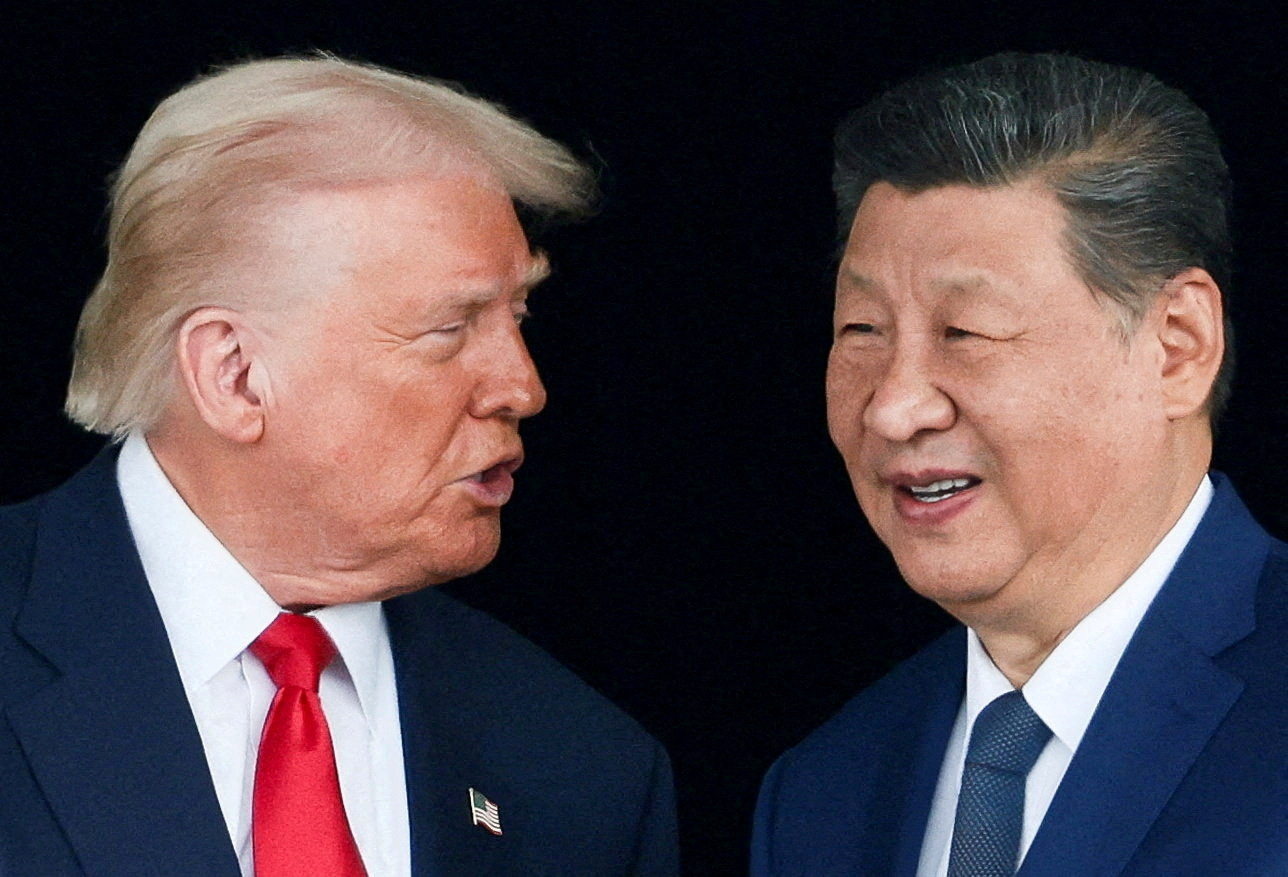 US President Donald Trump and Chinese President Xi Jinping talk as they leave after a bilateral meeting at Gimhae International Airport, on the sidelines of the Asia-Pacific Economic Cooperation (APEC) summit. [Evelyn Hockstein/Reuters]
