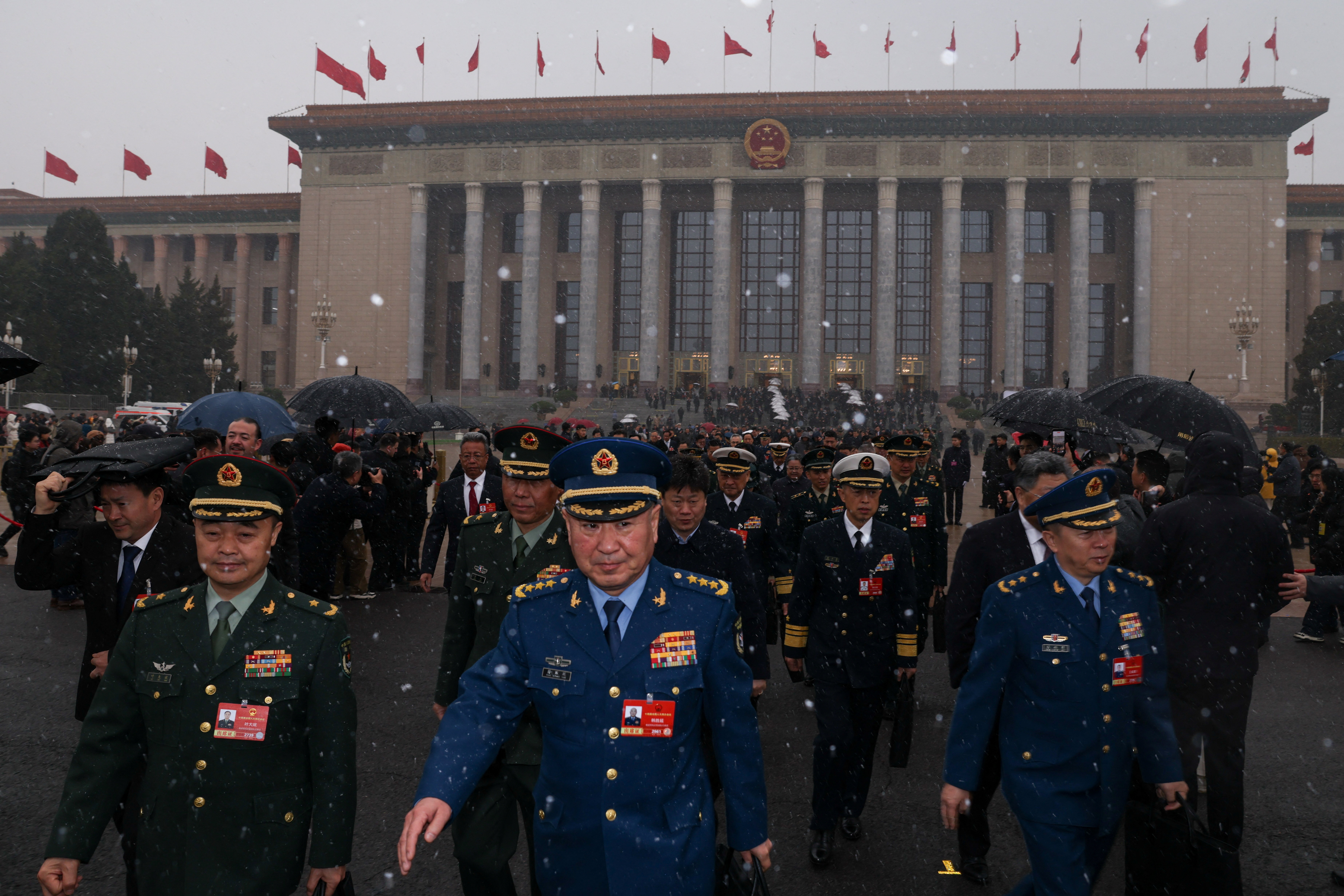 Members of the Chinese People's Liberation Army (PLA) leave the Great Hall of the People amid snowfall on Tiananmen Square, before the opening sessions of the annual Chinese People's Political Consultative Conference (CPPCC) and National People's Congress (NPC), in Beijing, China, March 4, 2026. REUTERS/Tingshu Wang