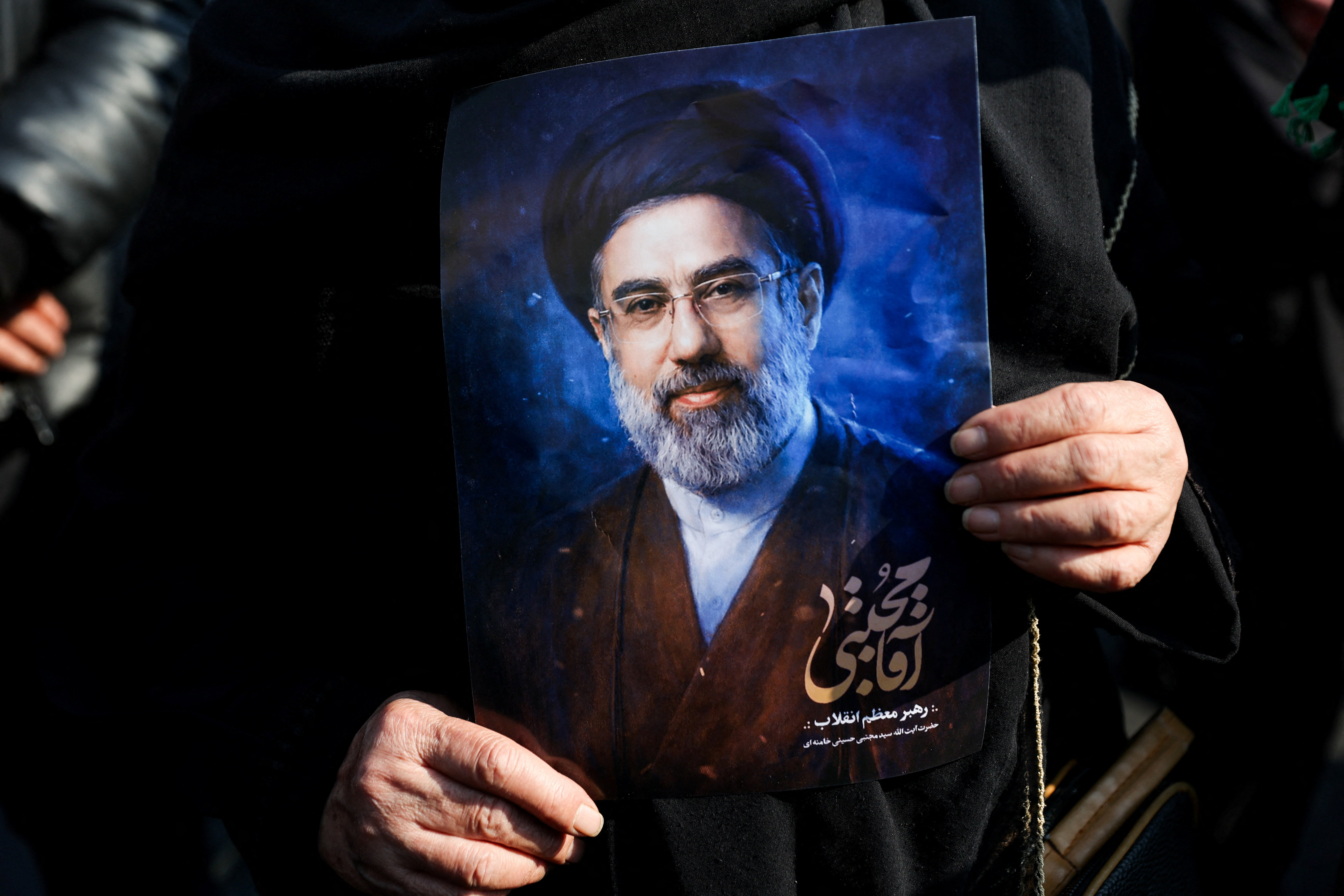 A woman holds a portrait of Iran's new supreme leader Mojtaba Khamenei