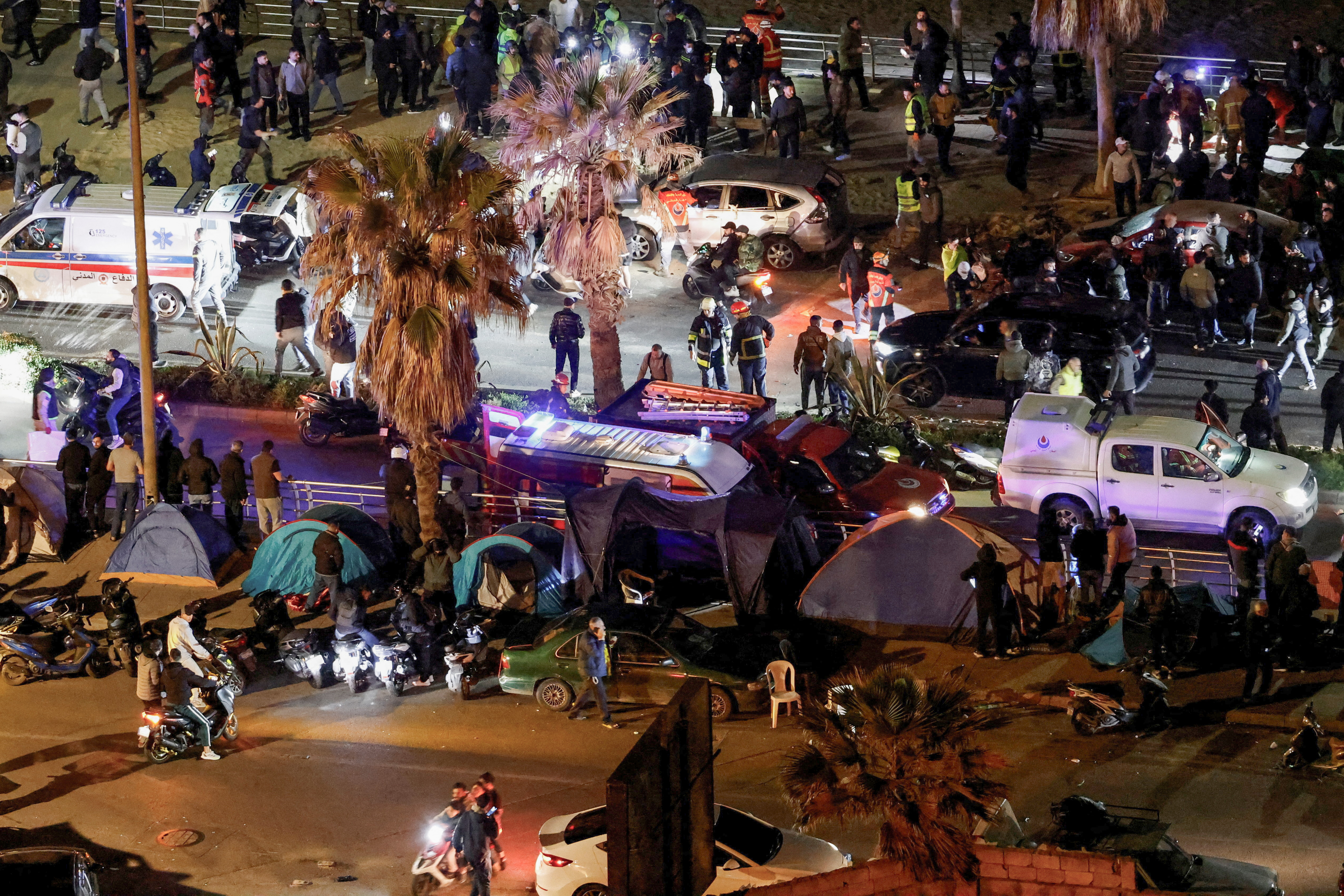 Emergency services vehicles and people gather at the site of a deadly Israeli strike in Ramlet al-Baida on March 12, 2006 [Jack Seikaly/via Reuters]