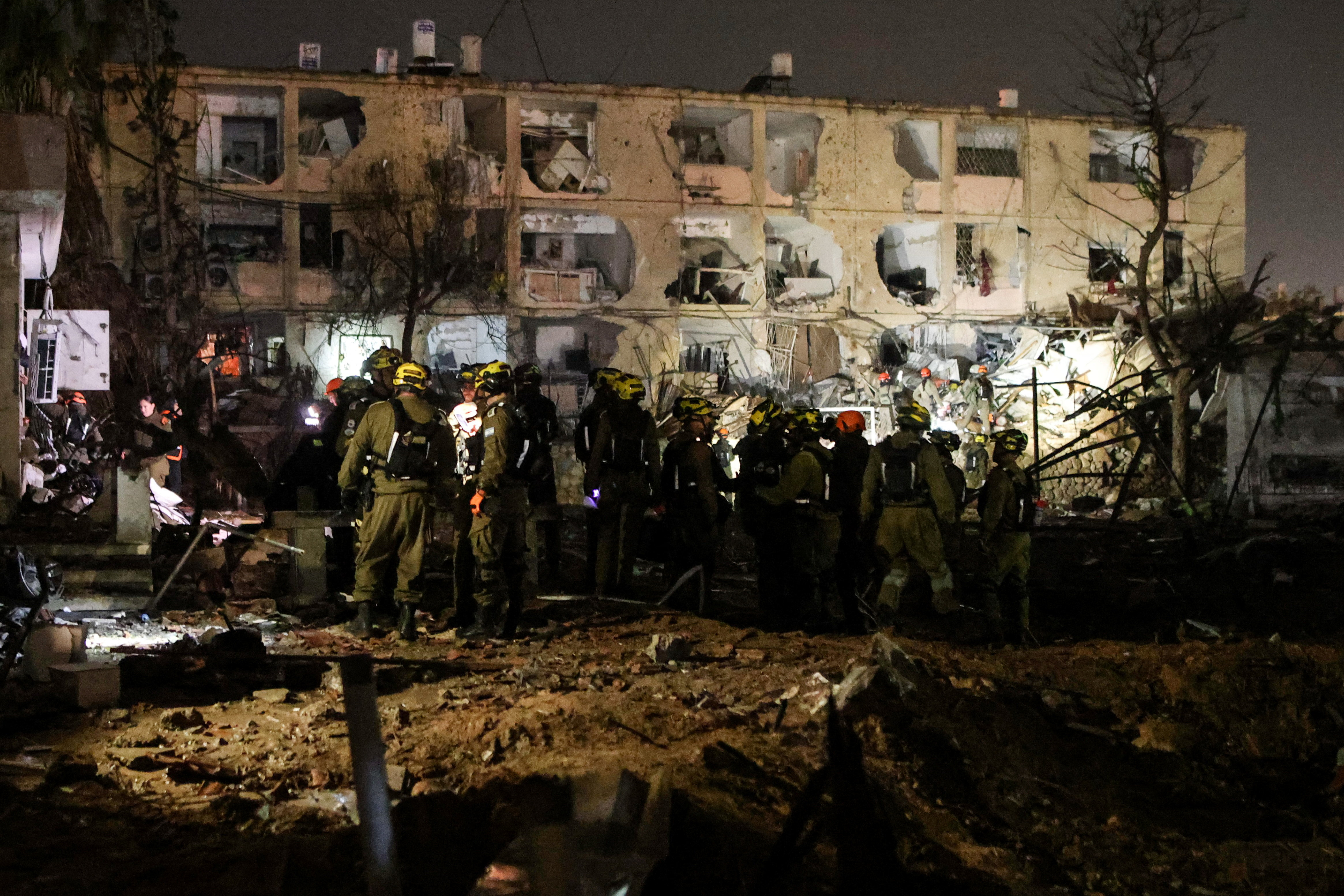 Israeli soldiers work at the scene of damage after Iranian missile barrages struck Dimona