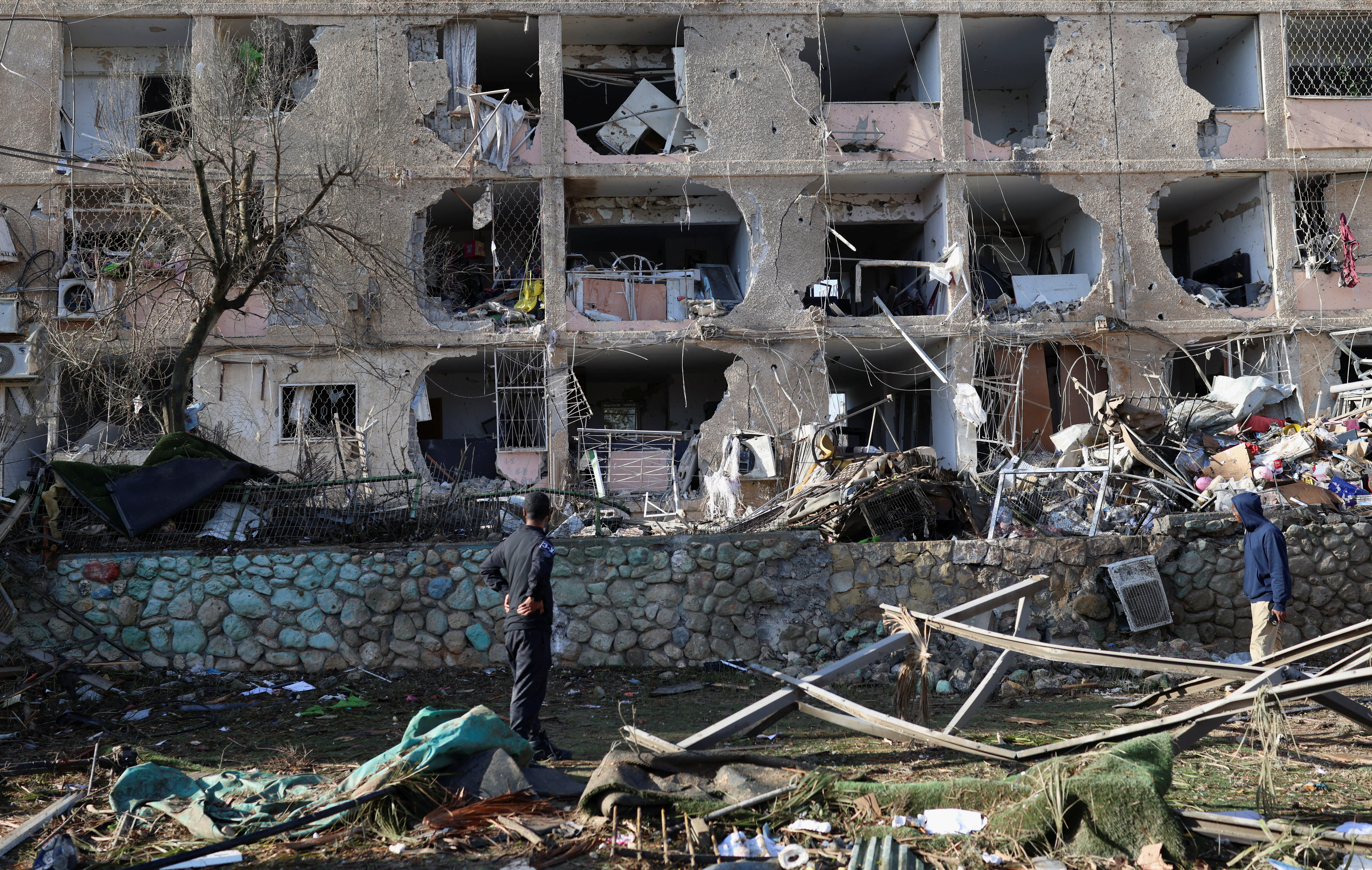 People stand at a damaged area following a night of Iranian missile strikes