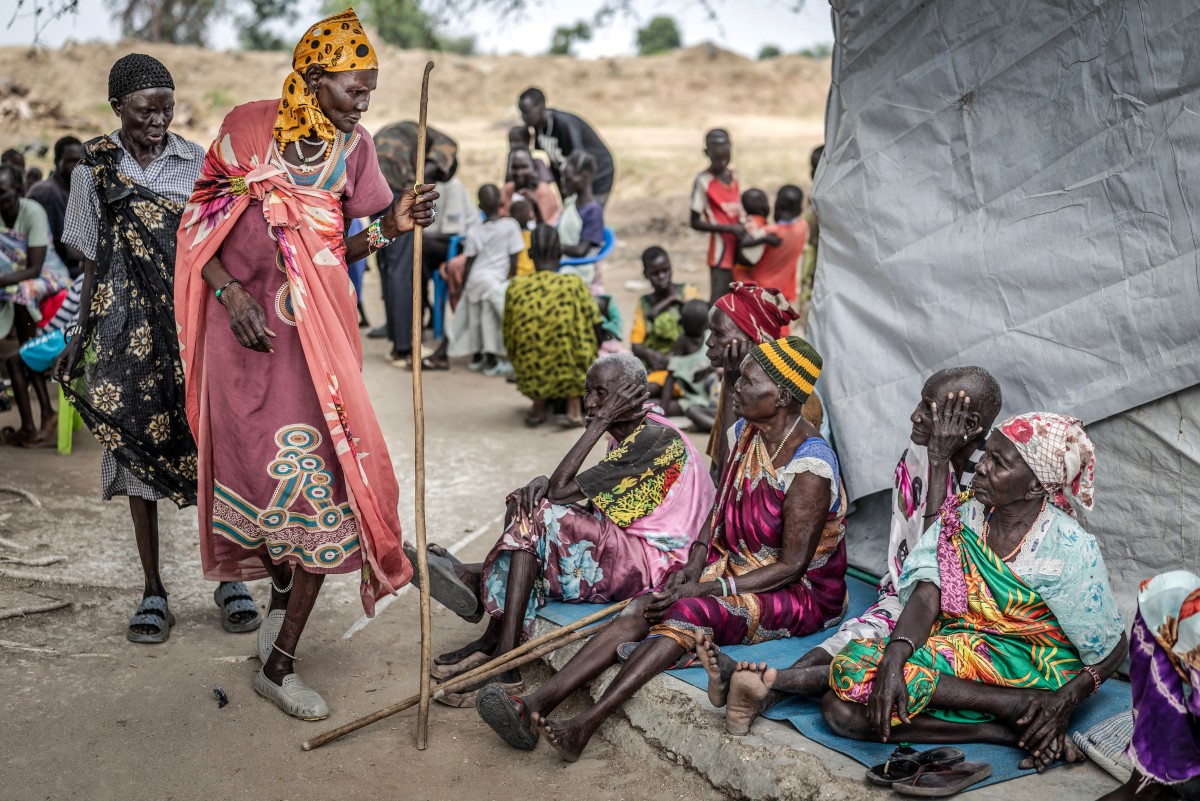 Elderly members of the Nuer community, uprooted by the conflict in Jonglei State, attend a community health session amid shortages of medical supplies in the POC IDP Camp in Bor, Jonglei State, on February 16, 2026. South Sudan gained independence in 2011 but quickly descended into civil war between rival generals, Salva Kiir and Riek Machar. A power-sharing deal in 2018 brought relative peace, with Kiir as president and Machar his deputy. But the deal was never fully implemented, their forces never unified, and elections never held. Over the past year, Machar has been jailed and violence has erupted between their forces in several areas. The worst has been in Jonglei state, where some 280,000 people have been displaced since December, according to the United Nations. (Photo by Luis TATO / AFP)