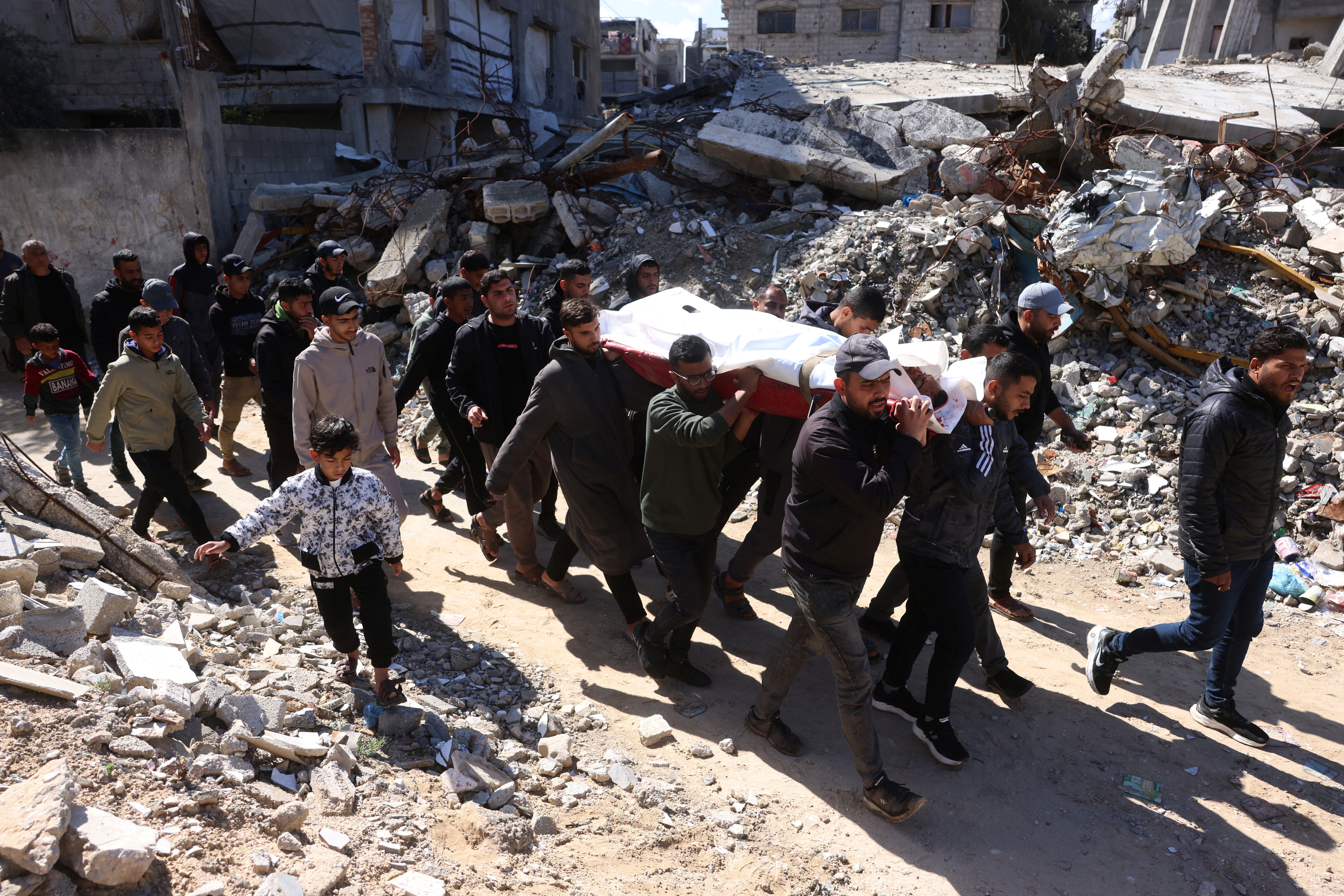 Palestinian men carry the body of a person killed in an Israeli military strike