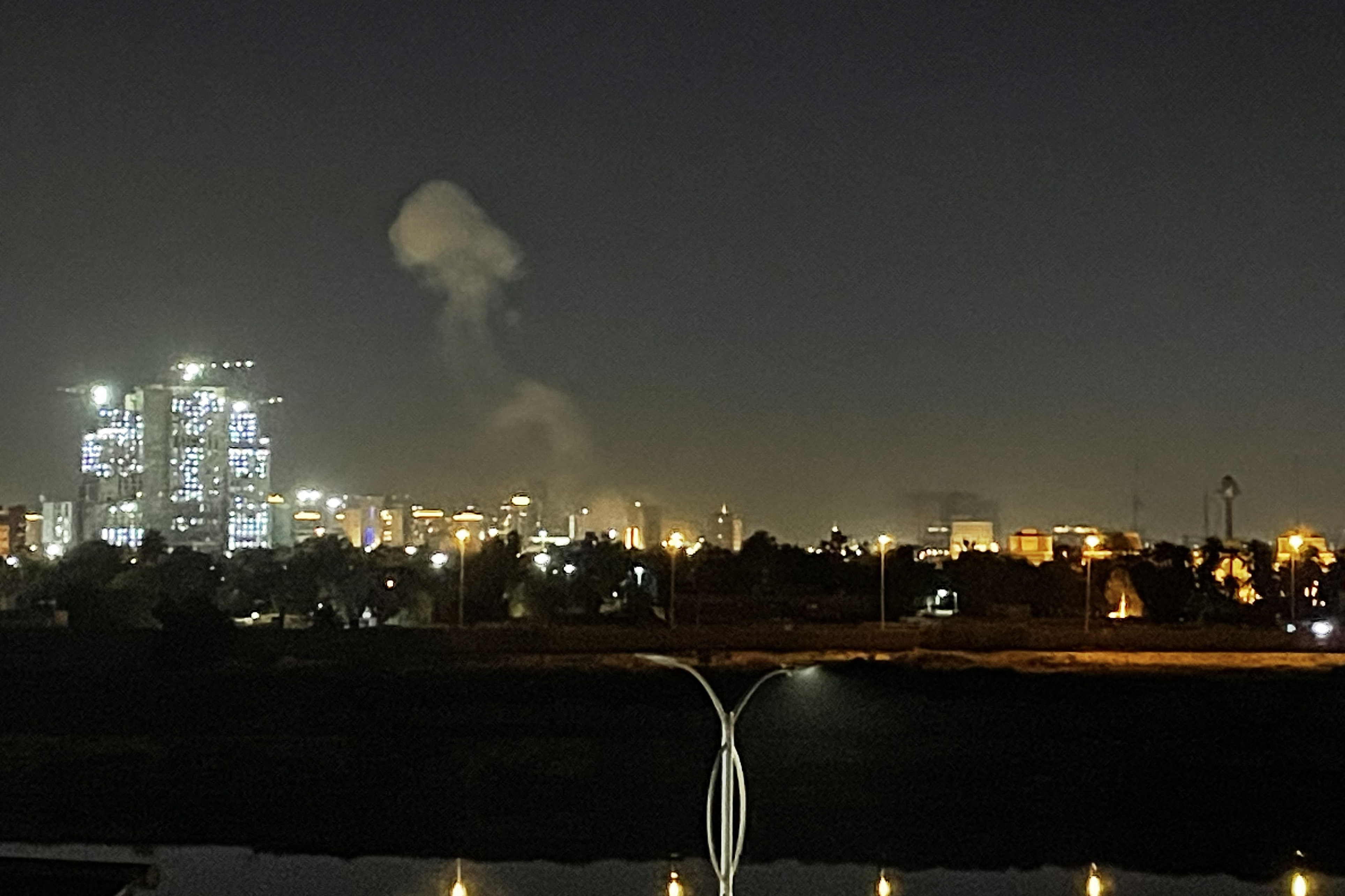 A plume of smoke rises over the Iraqi capital Baghdad