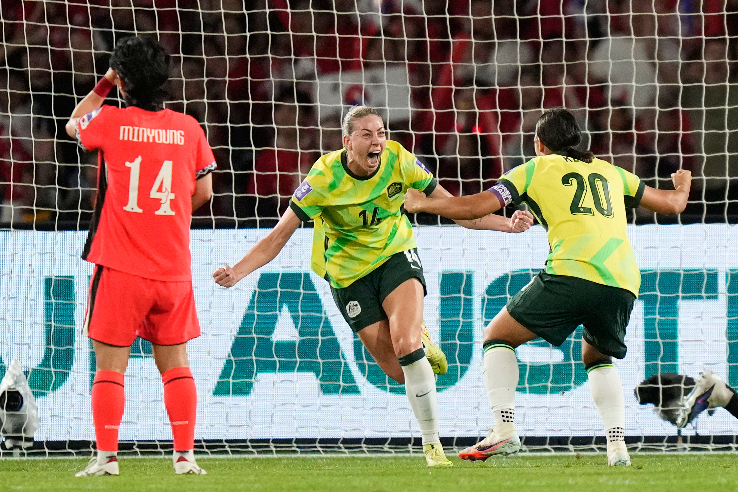 Australia's Alanna Kennedy, centre, celebrates with teammate Sam Kerr after scoring her team's first goal during the Women's Asian Cup soccer match between Australia and North Korea