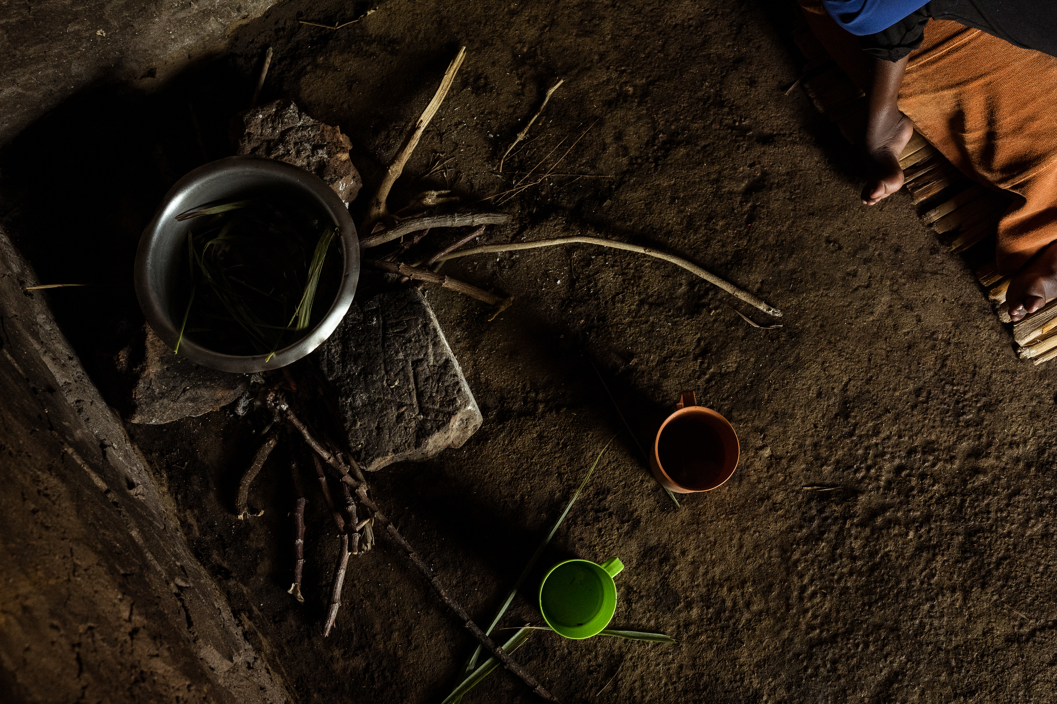 9th February 2026. Owalai, Uganda. Inside Martha Apolot's small home she cooks for her son Aaron on a stone fire liquid lunches. Aaron Elayu, 8 lives with an undiagnosed disability and is cared for solely by his young mother Martha after she fell pregnant in dubious circumstances at age 13. She has been shunned by her family and recieves little assistance from them. Photograph by Christopher Hopkins