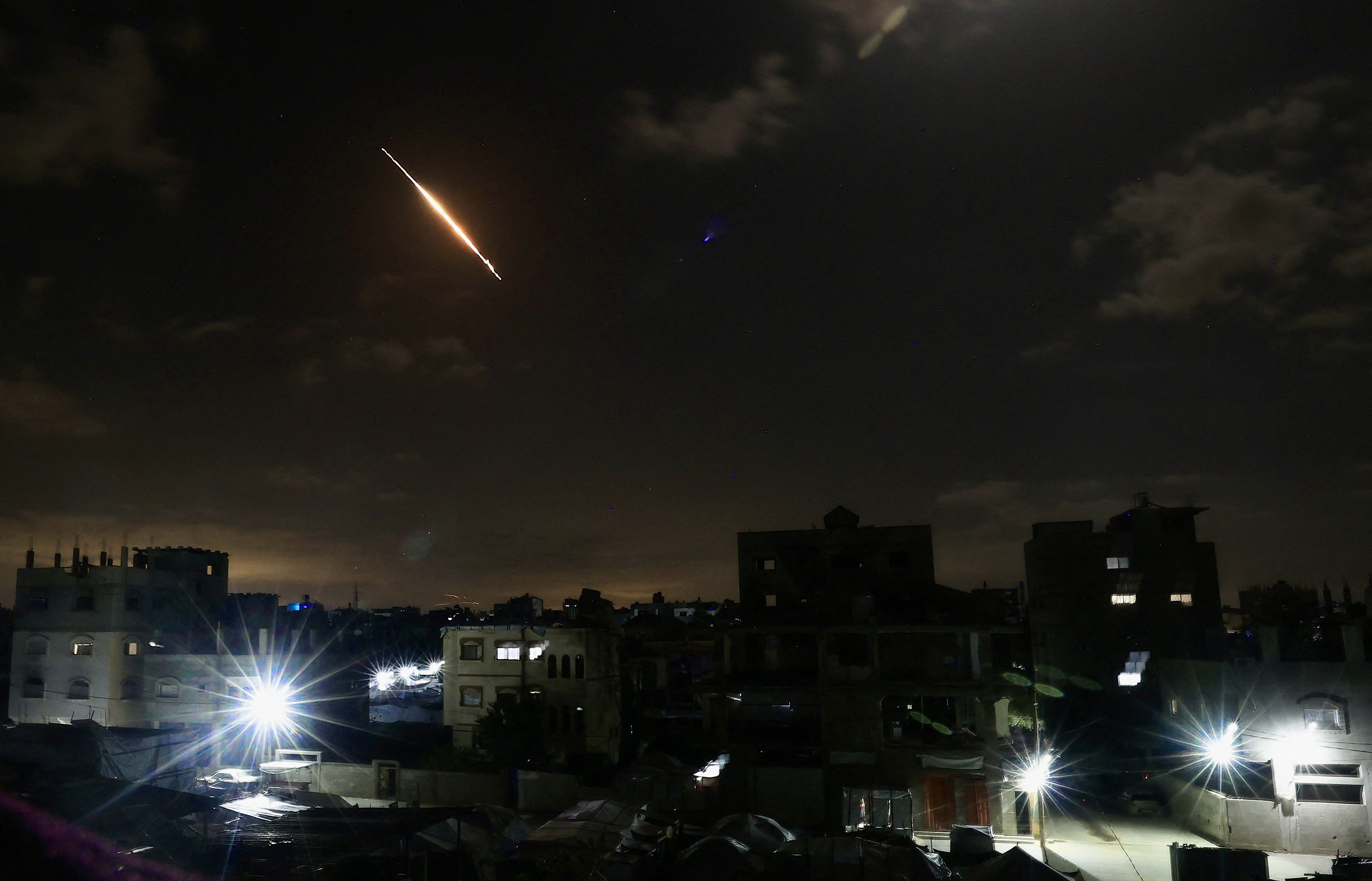 TOPSHOT - A projectile leaves behind a trail in the sky as seen from Gaza City on March 7, 2026.