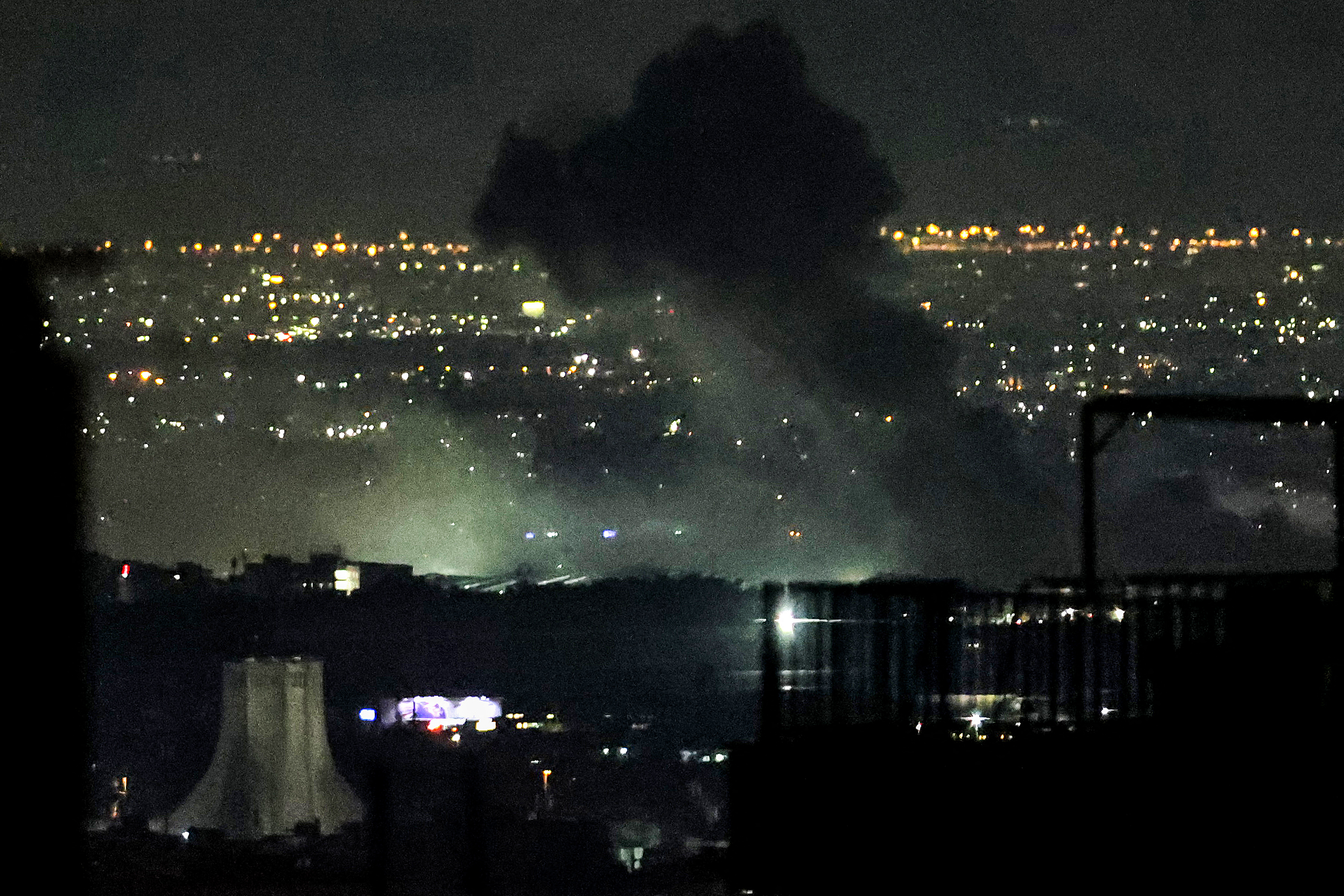 Smoke plumes billow from the site of air attacks.