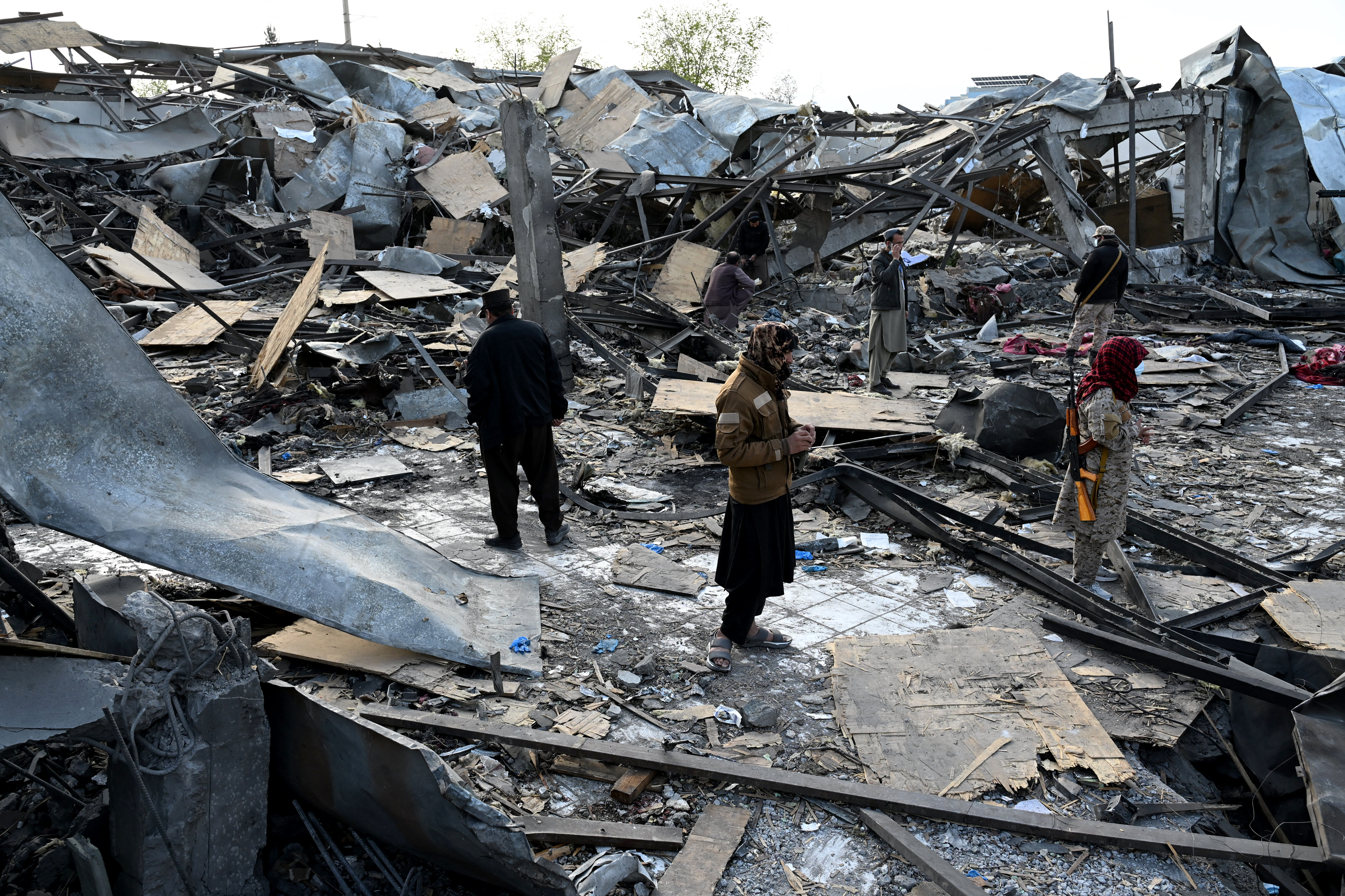 Taliban security personnel inspect the site after Pakistani strike on a rehab in Kabul