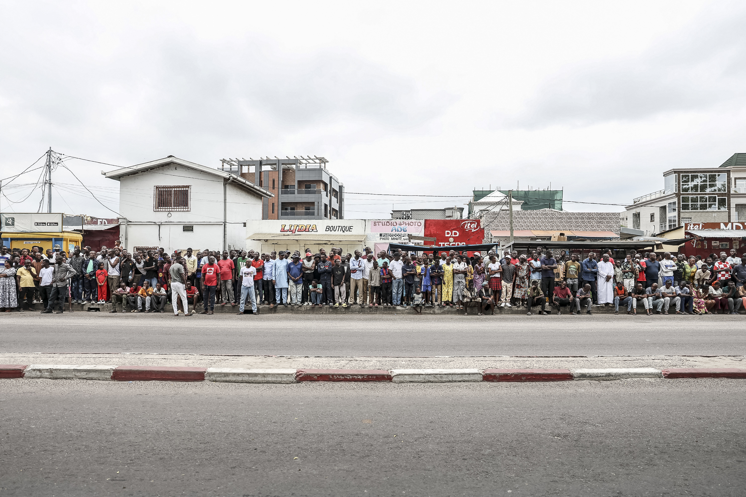 Supporters of incumbent President of the Republic of Congo and presidential candidate Denis Sassou Nguesso stand on the side of the road as they wait fot him to arrive at a polling station in Brazzaville on March 15, 2026 during the Republic of Congo's presidential elections. (Photo by Daniel BELOUMOU OLOMO / AFP)