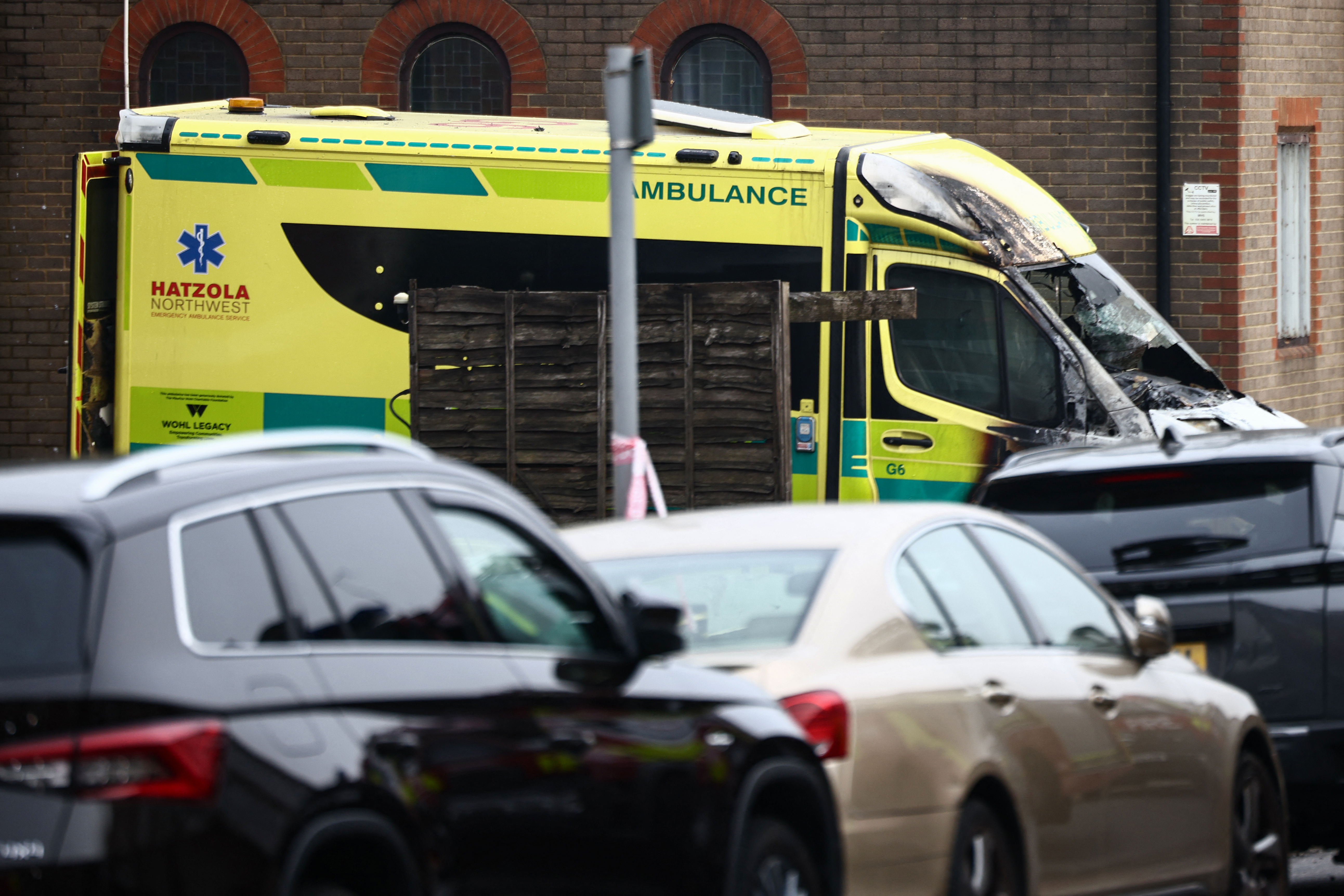A damaged and burnt out ambulance (C) is pictured along a street in the Golders Green area of north London on March 23, 2026, after volunteer ambulances run by a Jewish organisation were set on fire overnight.