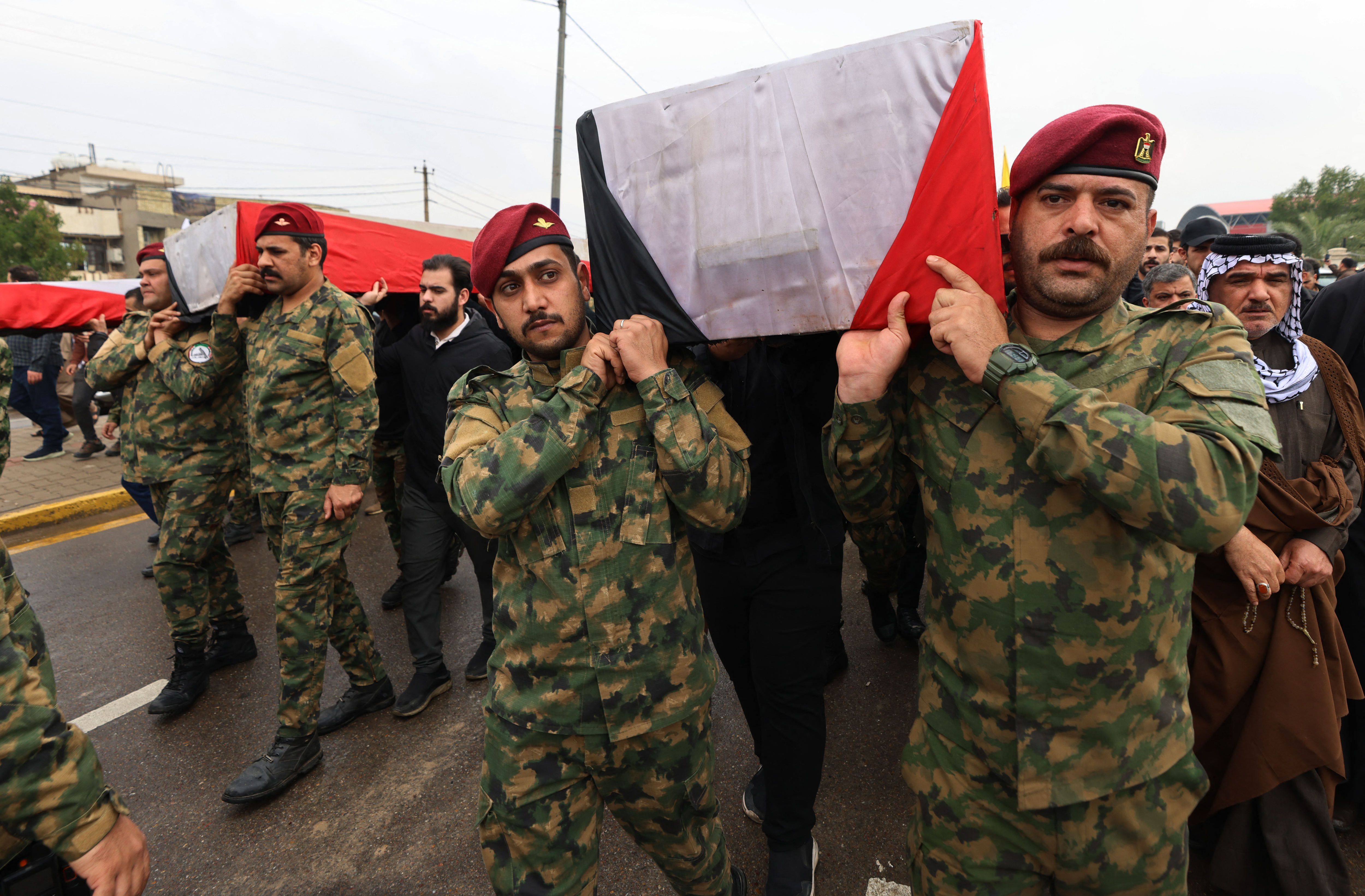 Members of Iraq's Hashed al-Shaabi, an alliance of factions now integrated into the regular army, carry the coffin of the Hashd al-Shaabi operations commander for Al-Anbar, Saad Dawai alongside others during a mass funaral in Baghdad on March 24, 2026.