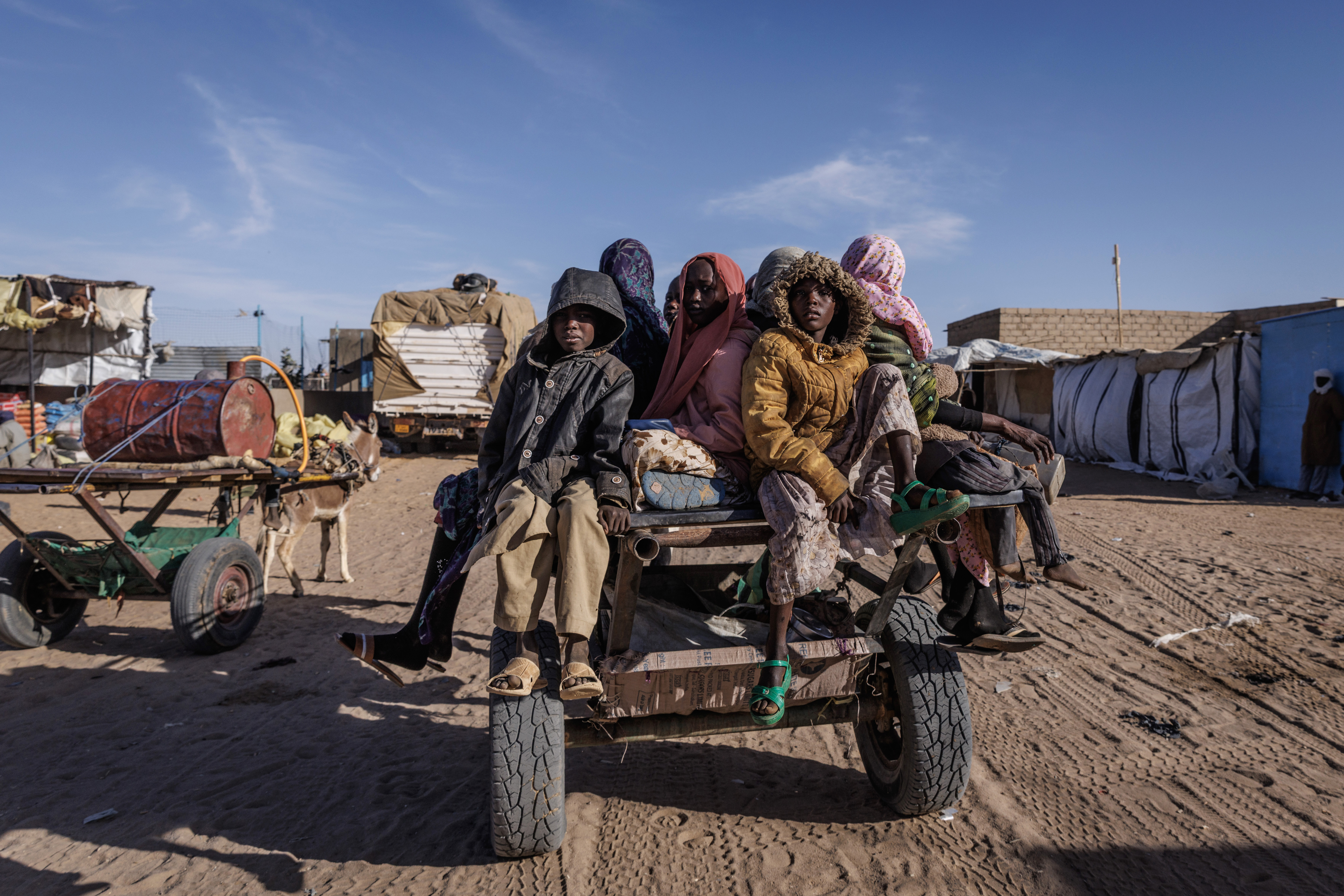 OURE CASSONI, CHAD - FEBRUARY 24: Newly arrived Sudanese refugees prepare to ride back to their temporary shelter after receiving food aid at the Oure Cassoni refugee camp on February 24, 2026 in Oure Cassoni, Chad. In April 2023 civil war erupted between the Sudanese Armed Forces (SAF) and the armed militia group Rapid Support Forces (RSF). The ongoing conflict has so far displaced around 14 million people across the region, triggering a widespread humanitarian crisis, as neighboring countries like Chad struggle to absorb refugees, while coping with populations already suffering high poverty rates and food insecurity. Chad has become Africa's largest host of refugees per capita, hosting a total 1.4 million refugees - more than 900,000 of which fled the conflict in Sudan. The most recent wave of arrivals from Sudan follows the RSF's offensive to capture the north Darfur city of El Fasher, where 6,000 people were reportedly killed by the RSF in the space of three days in October. A recent UN report has accused the RSF of atrocities that amount to war crimes and possible crimes against humanity. As many as 400,000 people have reportedly been killed since the conflict began. (Photo by Dan Kitwood/Getty Images)